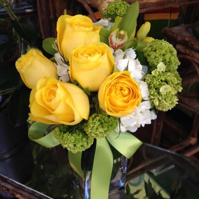 Rio Rio - Bright and Springy! Large yellow roses, white hydrangea, green cymbidium, yellow tulips. Colors can be adjusted to taste.