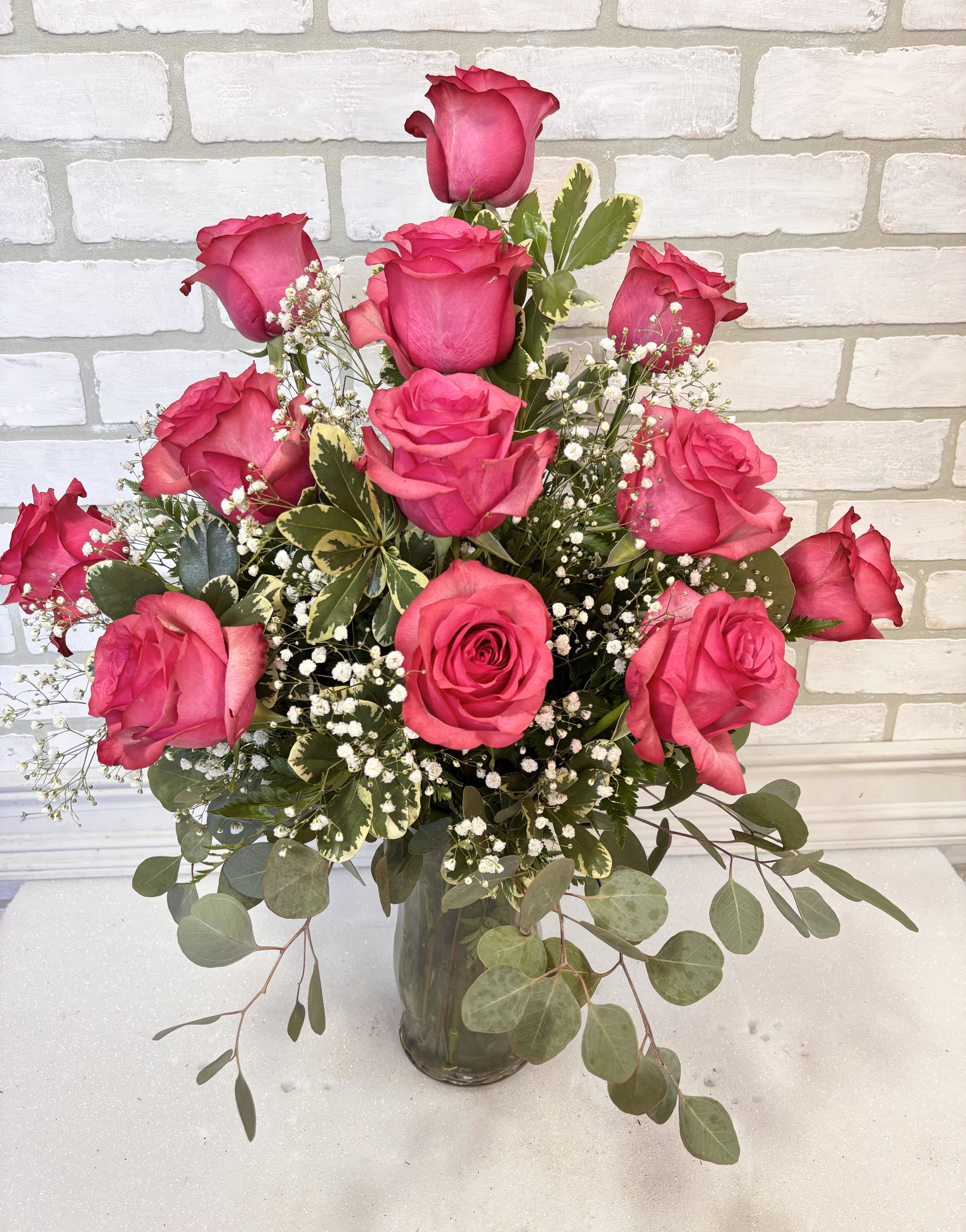 Hot Pink Dozen Roses - A dozen hot pink roses arranged in a vase with greenery and filler