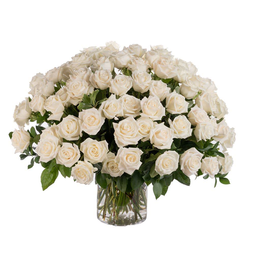 75 White Roses - Our classic 75 white roses are designed with long-stem 70 cm roses, rich greens in a clear glass urn.