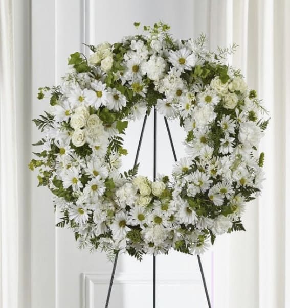 White SYMPATHY FUNERAL WREATH  - Wreath with white daisies, spray and regular roses, white carnations, white stock, white mums, bupleurum, and Tree fern, leather leaf greens. Funeral Wreath, Sympathy.22&quot; H x 22&quot; W