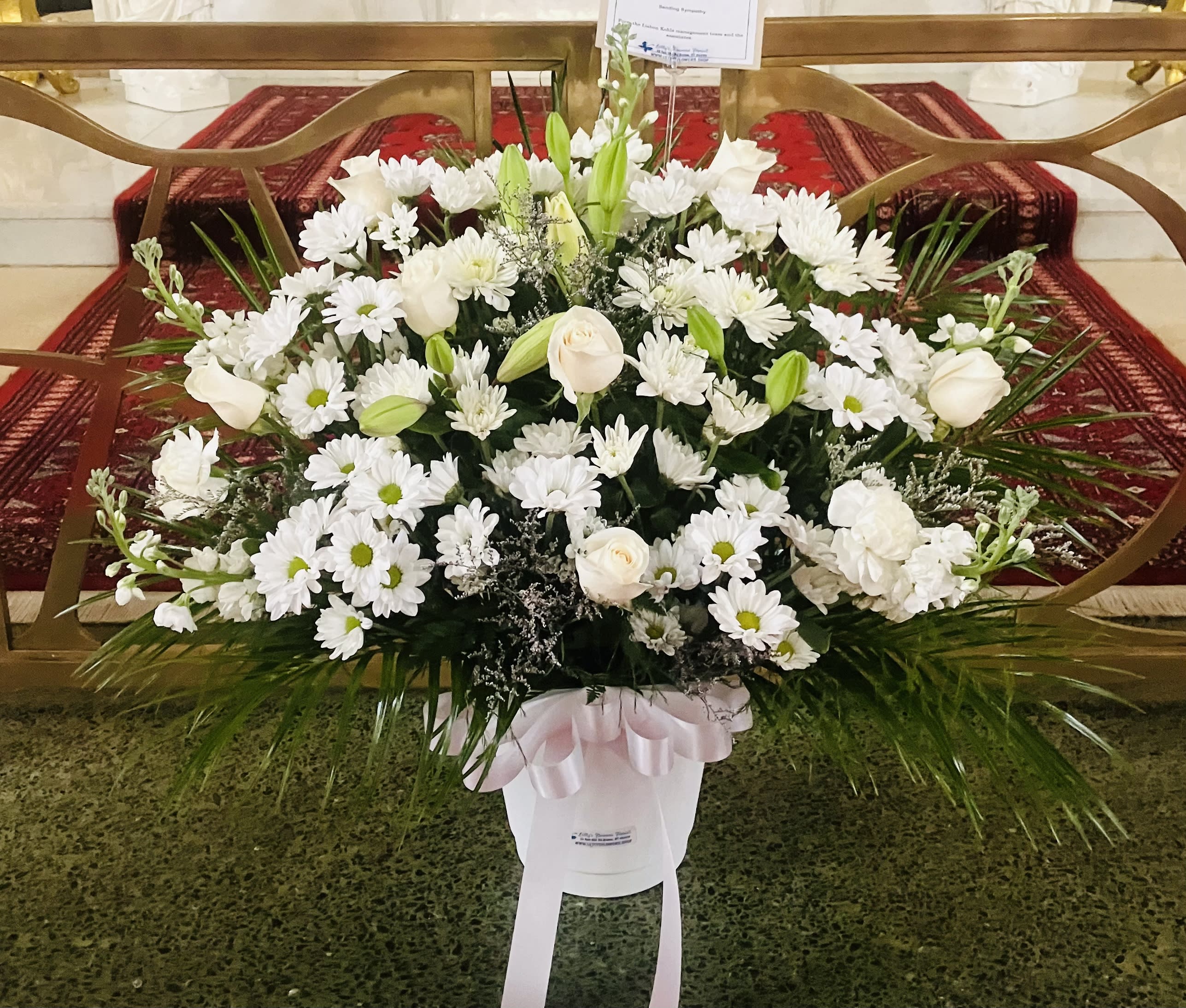 White Peace Sympathy Basket - Funeral basket. Fan shaped, one sided.  White flowers: Roses, Mums, Stock, Carnations, Daisies, Asiatic Lilies. greens, and White bow.