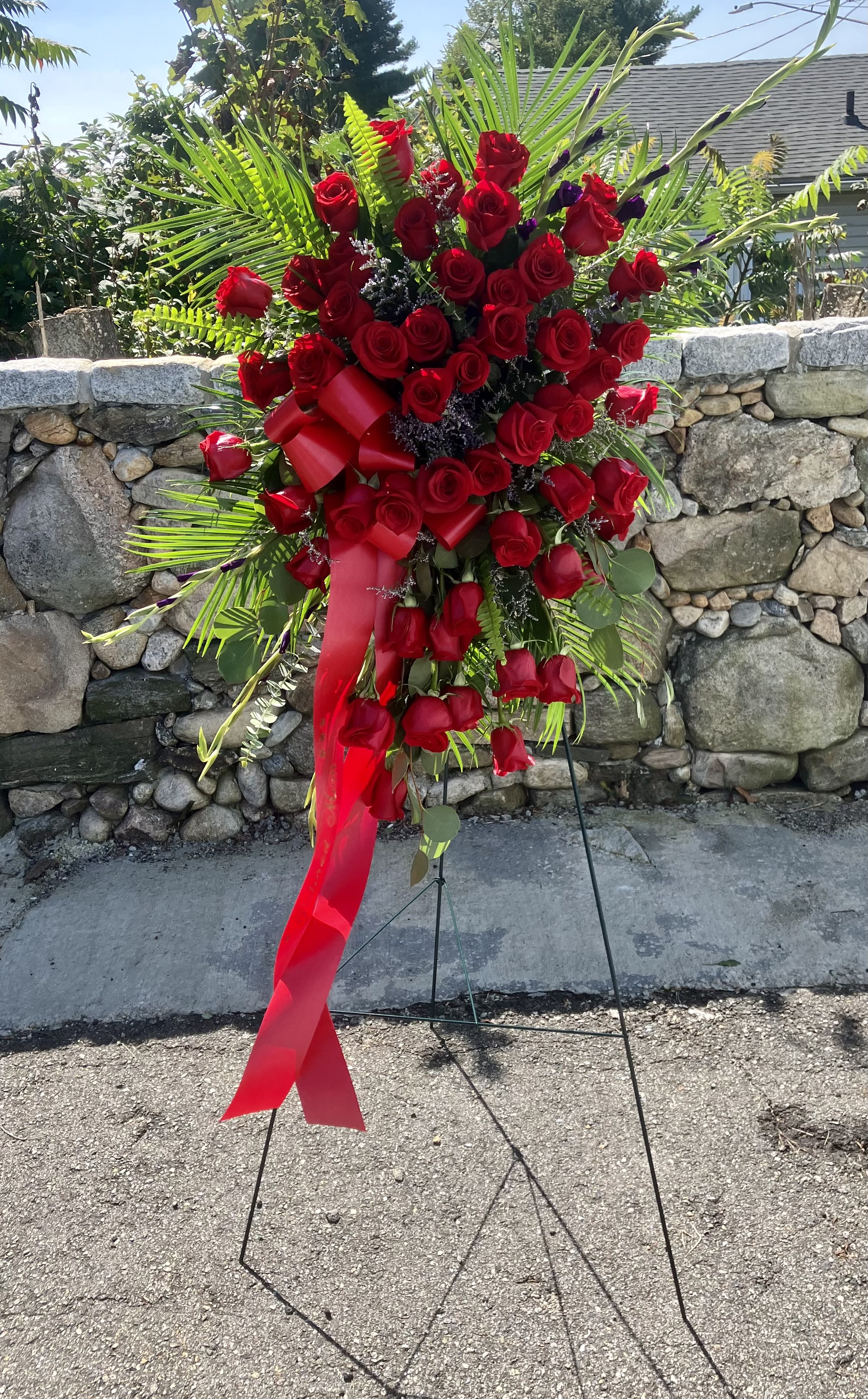 Tear of Roses Sympathy Arrangement  - Beautiful Sympathy flower arrangement with 24 Red Roses, Purple Gladioli, Eucalyptus, Limonium, Leather Leaf and Red Ribbon with a beautiful message. Easel 53” H  Deluxe 50 Roses 