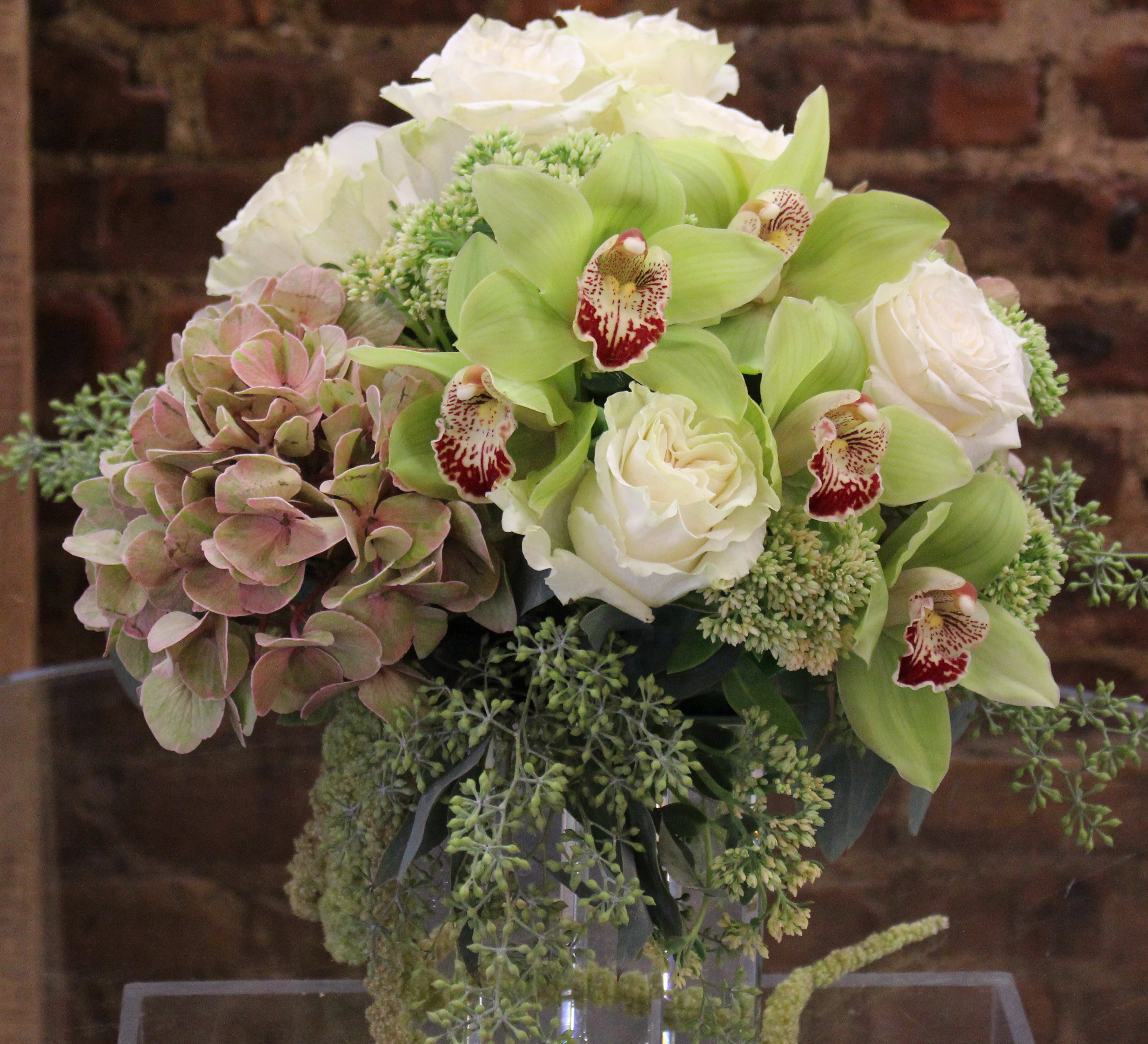 Organic Nature - A organic design of fresh green cymbidiums and rustic hydrangeas, dressed with a touch of white.  Orientation: All-Around All prices in USD ($) Standard, Deluxe (SHOWN), Premium 