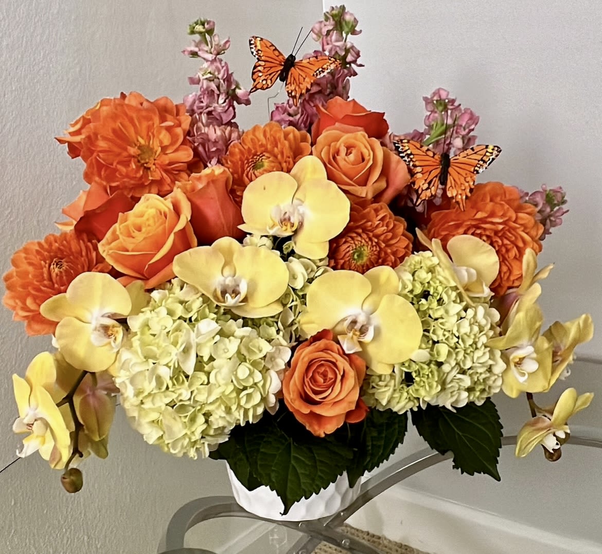 Sunbusrt NF-Y29 Sunbusrt NF-Y29 - What a great combination between orange and yellow in this lovely floral design. featuring a beautiful colombian roses , hydrangeas with a pale yellow shade and gorgeous Phaleanopsis blooms cascading the like a water fall.