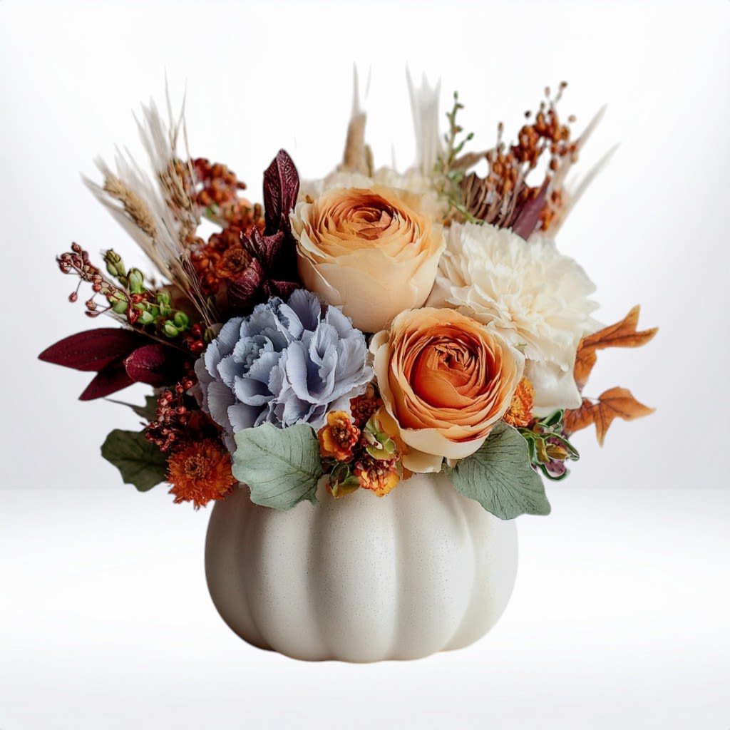 Buttered Maple Bloom -  Creamy white and warm apricot blooms are nestled beside baby blue hydrangea, burnt copper petals, and dried fall accents — all tucked in a ceramic pumpkin vase. Rustic and refined, it’s the perfect gift for Thanksgiving, fall birthdays, or hostess arrangements.  Available for same-day flower delivery in Galveston, TX, including nearby areas like Jamaica Beach, Bayou Vista, and La Marque.  Substitution Disclaimer: Due to seasonal availability, some blooms may be replaced with similar varieties of equal or greater value to maintain the design’s look and integrity. Your arrangement will always reflect the same spirit, palette, and premium quality.   