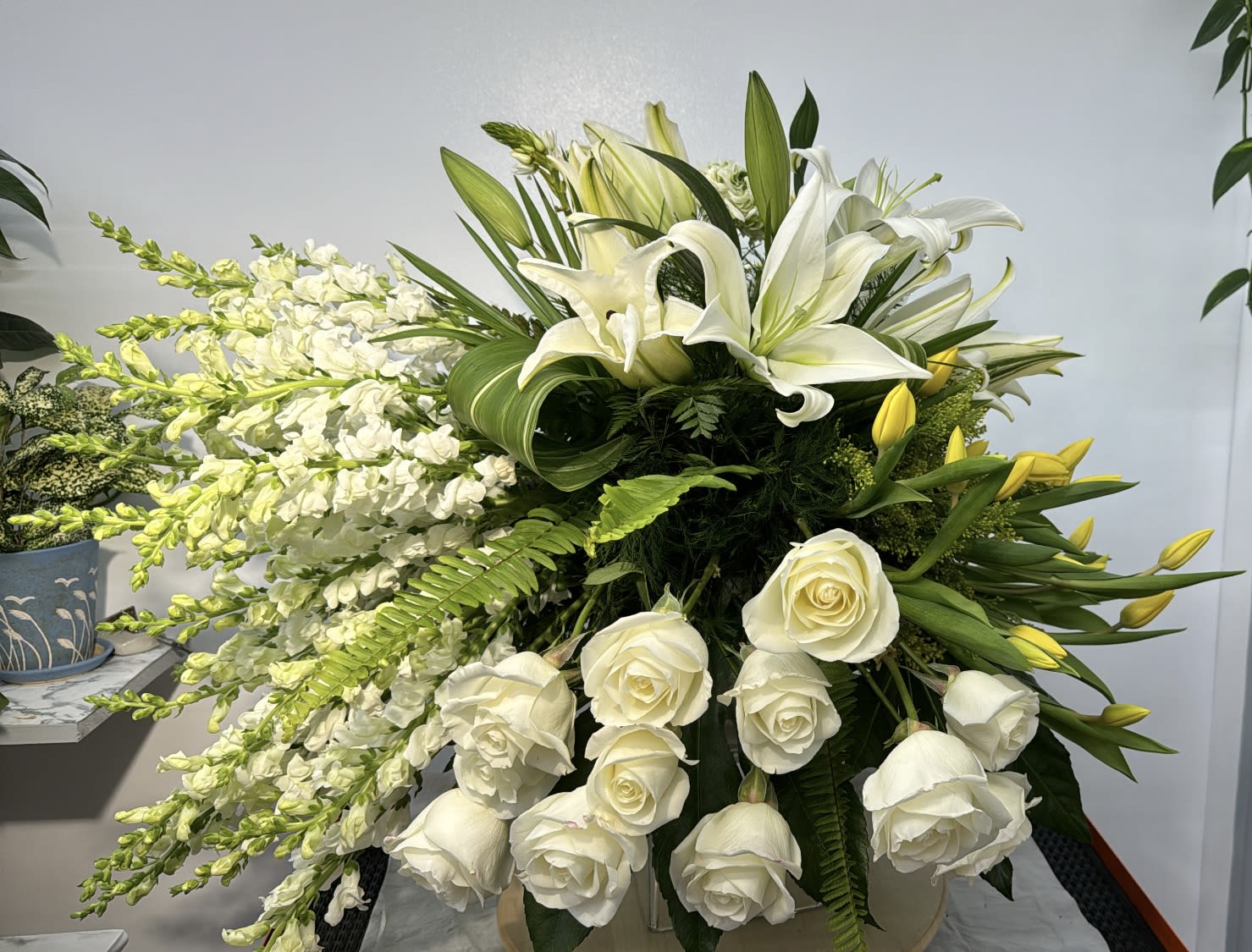 Blooming at Dawn  - This rich and vibrant design is certain to lift their spirits! Filled with white lilies, white roses, and yellow tulips paired with snapdragons,  and asters, Blooming at Dawn will brighten their day. Send it today and treat them to a surprise!