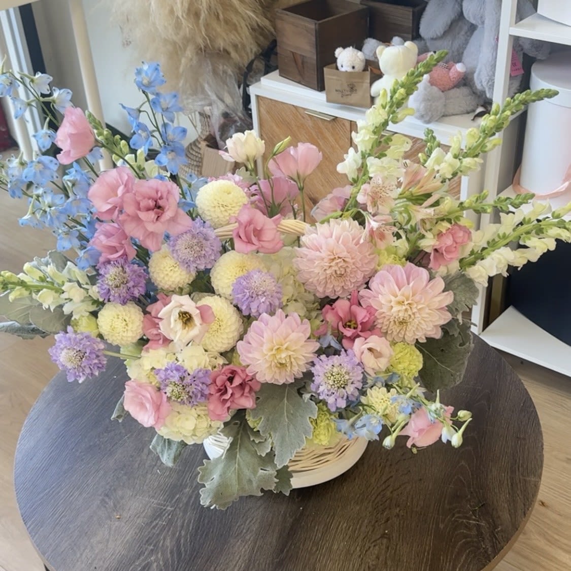 Soft Elegance Basket - This pastel flower basket is designed to capture the beauty of a blooming garden. With dahlias, lisianthus, chrysanthemums, delphinium, snapdragons, and seasonal accents in shades of pink, lavender, blue, and cream, it creates a soft and romantic look. Styled in an elegant white basket, it’s the perfect choice for birthdays, anniversaries, baby showers, or simply to bring joy into someone’s home. Order from Hollywood Blooms for next day flower delivery in Los Angeles, and enjoy a luxury arrangement that feels fresh, natural, and unforgettable.