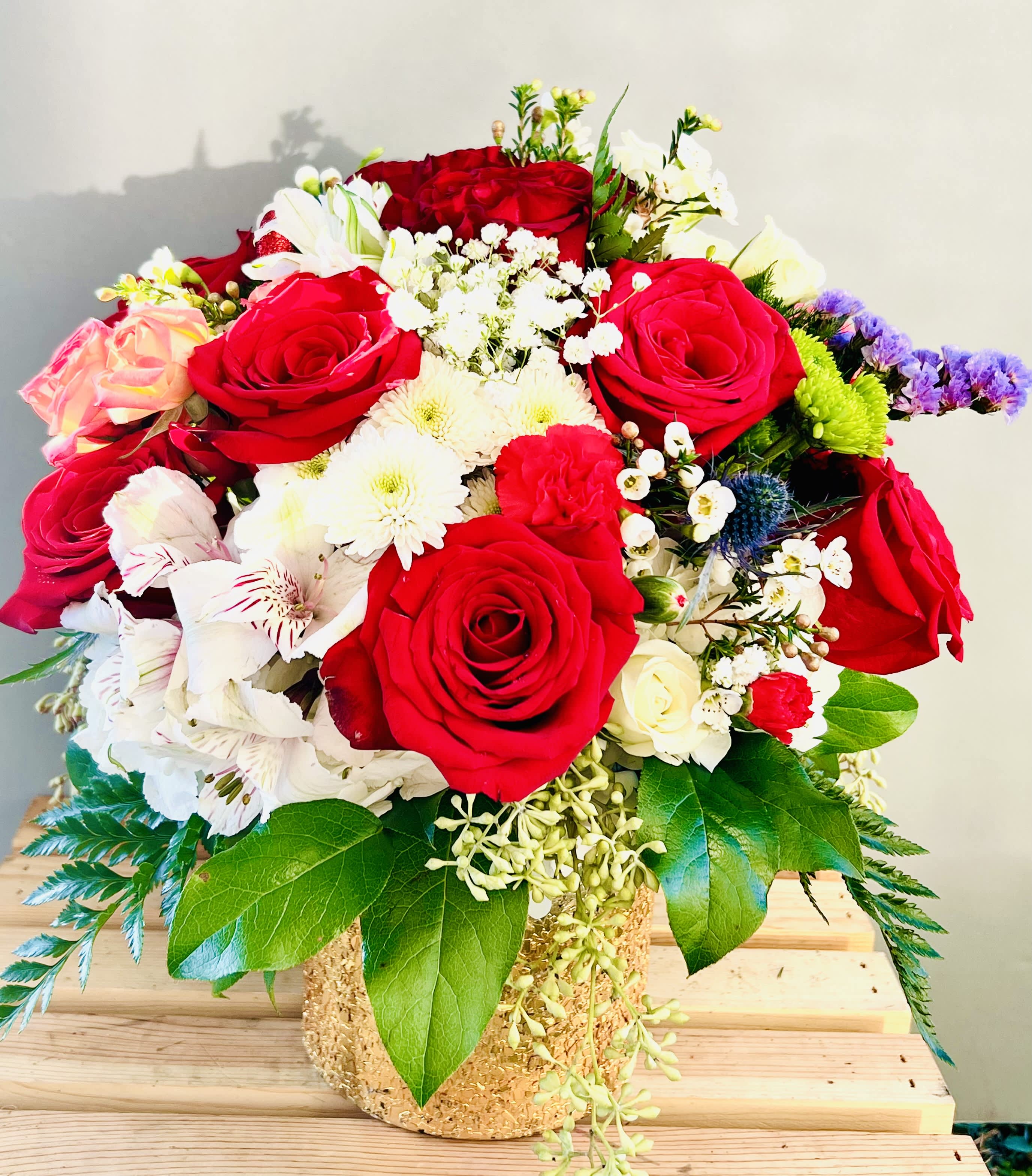 Charisma - An elegant assortment of premium  red roses , accent flowers and seasonal greens in a designer vase.Enter your zip code to check if you qualify for Free Delivery.For same day delivery and Free Delivery Options,Text or Call  832-973-1376.