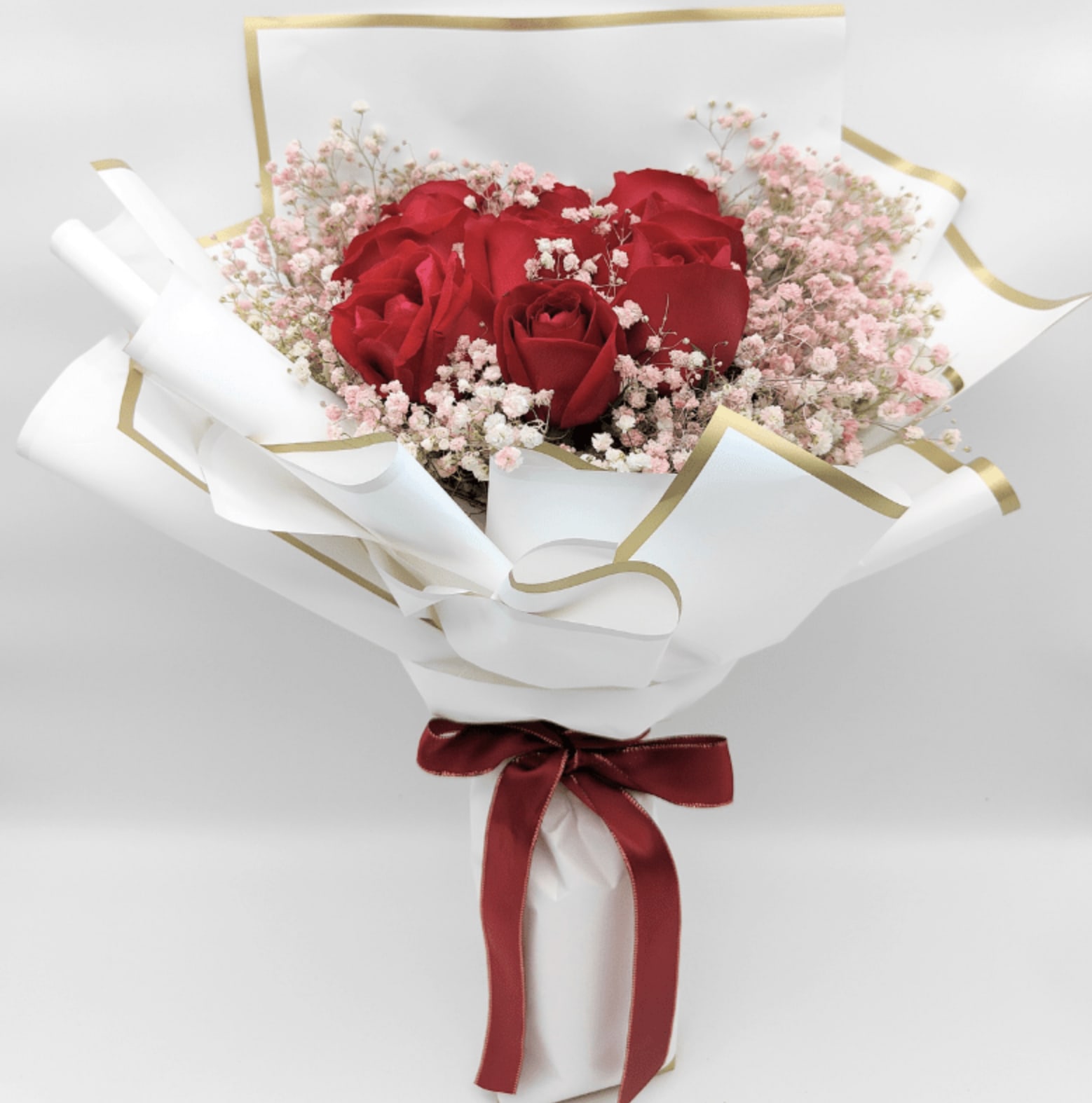 Amour Rouge - A classic and timeless bouquet that speaks straight from the heart. Featuring bold red roses surrounded by delicate pink baby's breath, wrapped in elegant white and gold paper and tied with a rich crimson satin ribbon. This bouquet is perfect for celebrating anniversaries, romantic moments, or simply reminding someone how deeply loved they are.