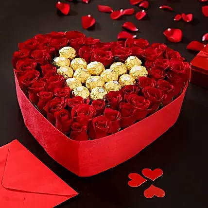Sweetheart Treasure Box - A luxurious heart-shaped box overflowing with passion and indulgence. This romantic arrangement features a stunning bed of fresh red roses, delicately encircling golden Ferrero Rocher chocolates — the perfect pairing of elegance and sweetness. Whether it's a grand gesture of love, an anniversary surprise, or a heartfelt &quot;I miss you,&quot; this arrangement says it all with timeless charm.