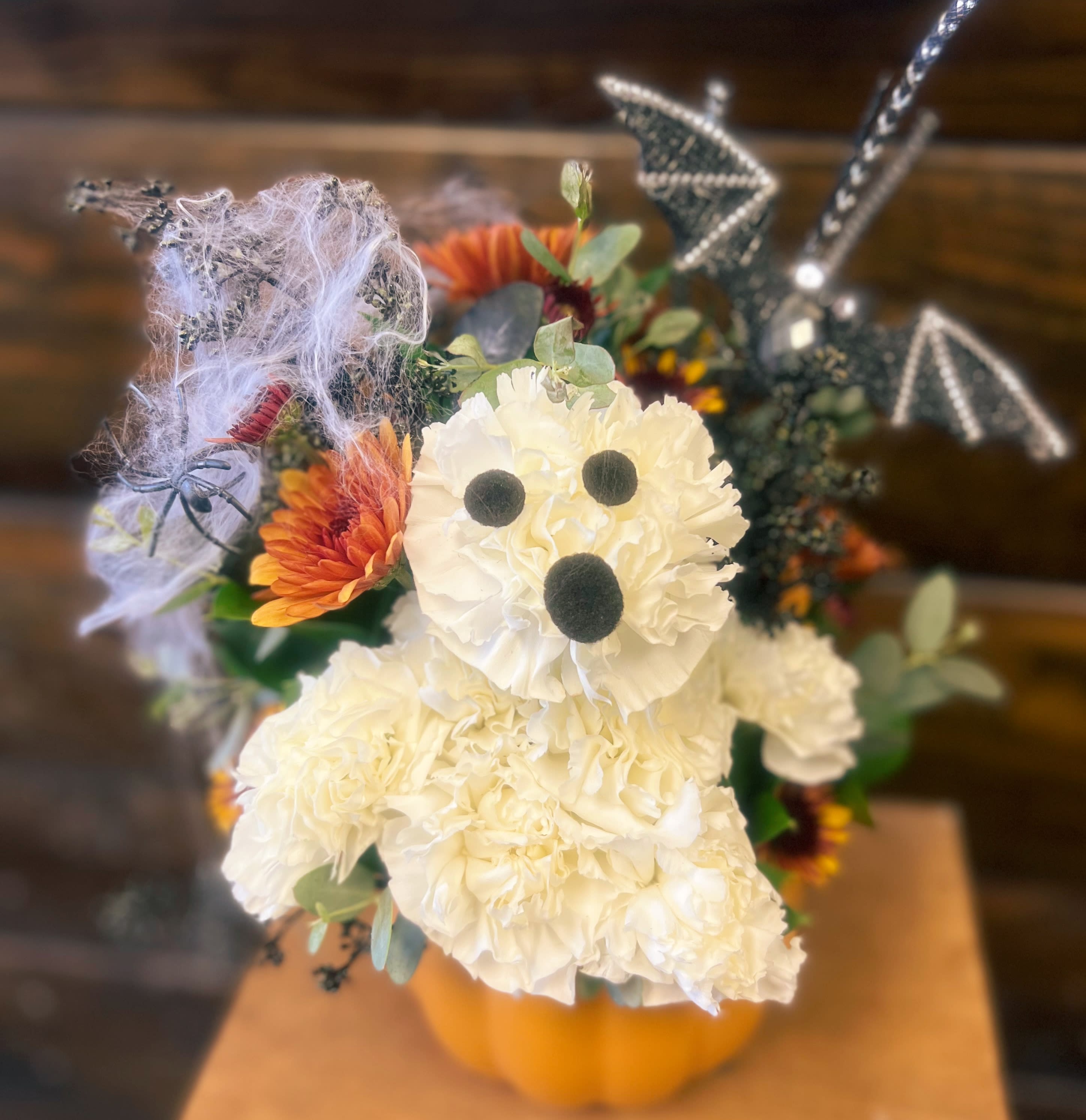 Scottsdale’s Little Ghost Scottsdale’s Little Ghost - Meet our cute Halloween Ghost! Ready to say happy halloween to your nearest and dearest. Container, colors and florals may vary depending on availability. Shown is a standard arrangement, deluxe adds more flowers to the same container for a fuller look. Premium is a bigger vase container and more flowers.