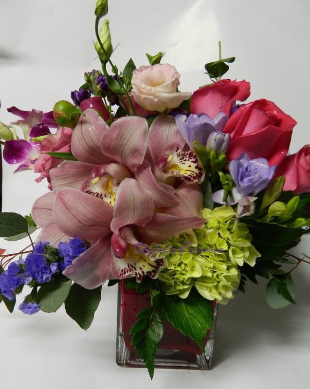 CC #3629 orchids and friends CC #3629 orchids and friends - Orchids and Friends Floral Cube This exquisite mix of feminine blooms is a breath of fresh air! Soft pinks and purples blend beautifully with a modern pop of green hydrangea, all artfully arranged in a chic lavender cube vase lined with a tropical aspidistra leaf. Perfect as a cheerful pick-me-up, thoughtful gift, or stylish décor piece—this arrangement brings joy anytime, anywhere.