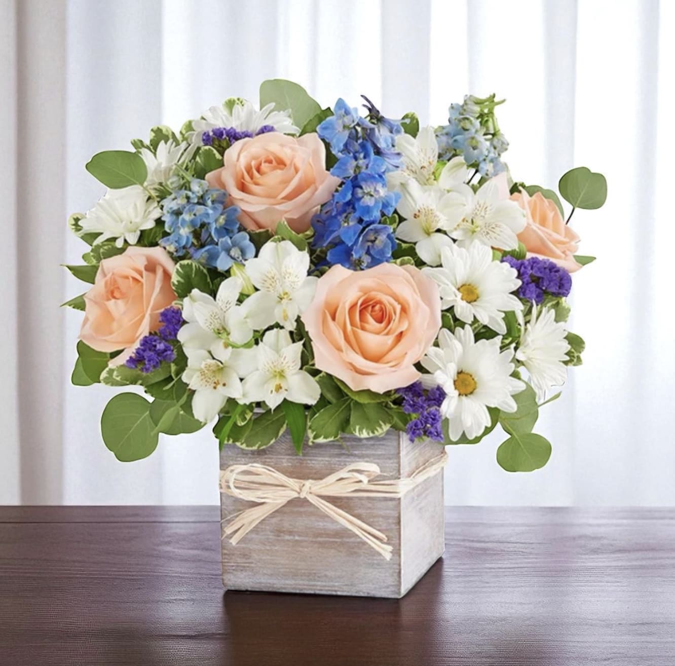 Sweet Sentiments Sweet Sentiments - This adorable arrangament consists of peach roses, blue delphinium and white daisy and alstroemerias. All placed in a wooden square box.