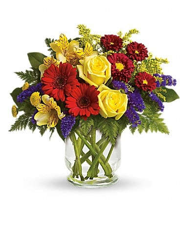 Garden Parade Garden Parade - You'll want to put this colorful bouquet on your hit parade of gifts to send. Bold primary colors and a perfect mix of flowers make it great for men and women of all ages. In other words, it's a perfect arrangement. Yellow roses, alstroemeria, and button spray chrysanthemums, red miniature gerberas and matsumoto asters along with purple statice, salal and fern are delivered in a lovely hurricane vase. It's a garden parade to be proud of!