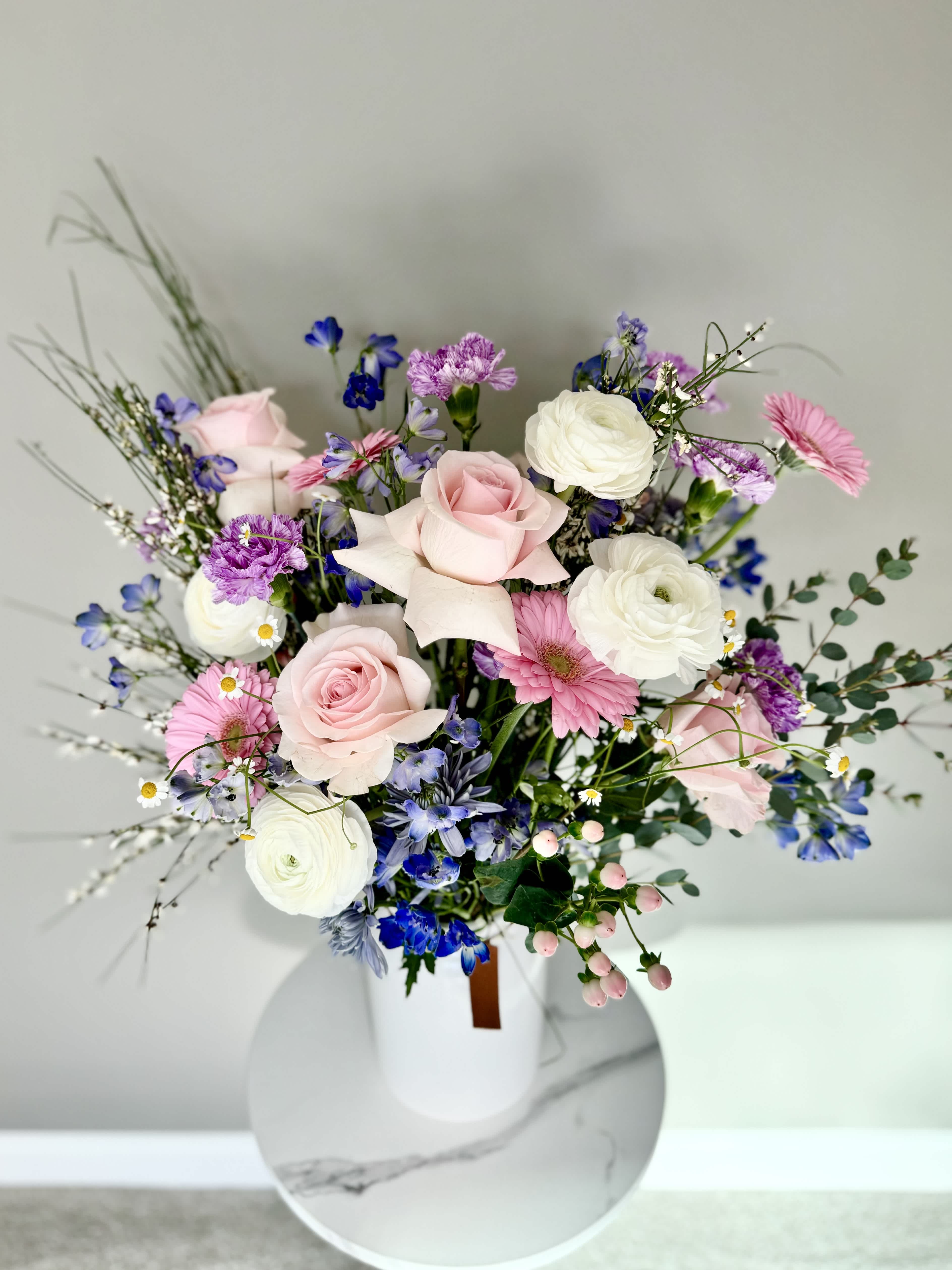 Blue Ruby and Pink Blossoms - IMPRESS that inspiring woman in your life with this lovely and elegant bouquet. Bright colors of pink and vivid colors of blue were carefully selected for this arrangement to exemplify how feminine and strong women are.  Send this bouquet to your Wife, Mom, Sister, Boss or Colleague, it will surely make her day brighter! This arrangement will be delivered in a special white ceramic vase that is especially selected for this arrangement. 