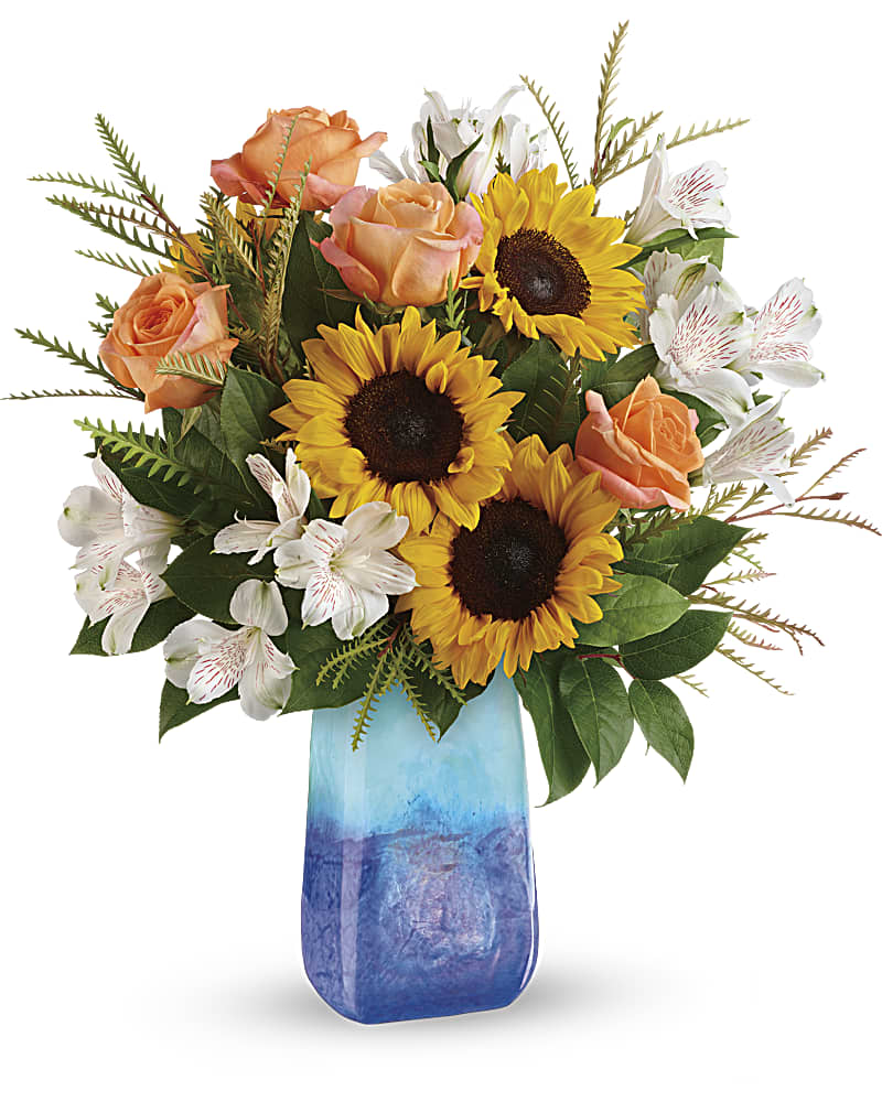 Sunflower Beauty Bouquet - This magnificent arrangement of golden sunflowers and orange roses, presented in a hand-blown art glass vase, brings the beauty of an ocean sunset to any occasion.