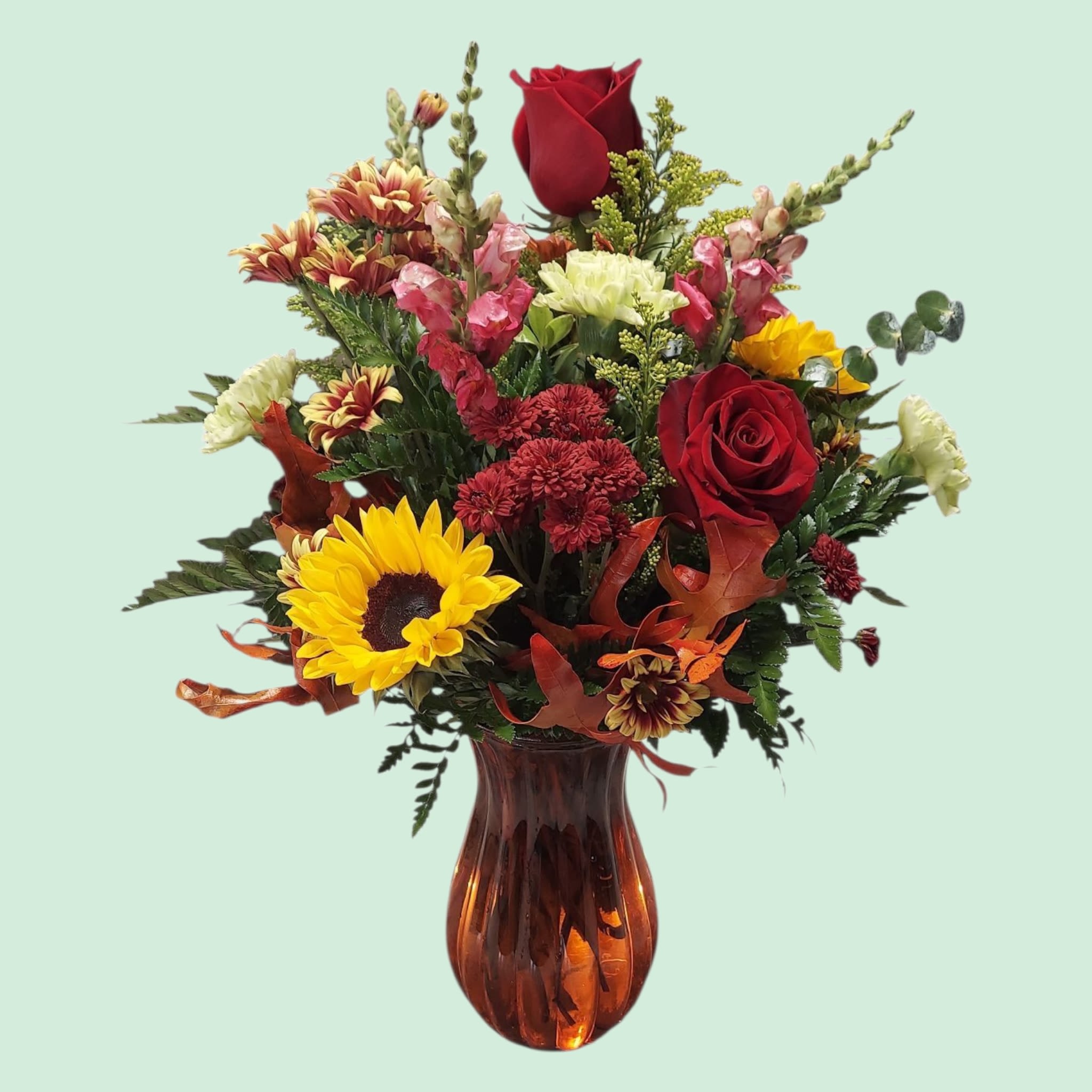 Fall Fire Vase Fall Fire Vase - All the colors of autumn are represented in our Fall Fire Vase. A colorful mix of sunflowers, roses, snap dragons, and fall blooms are displayed in a fall Jenna vase. COLORS OF FLOWERS AND VASE WILL VARY WITH AVAILIBILITY. APPROXIMATE SIZE: 20" H x 16"W.