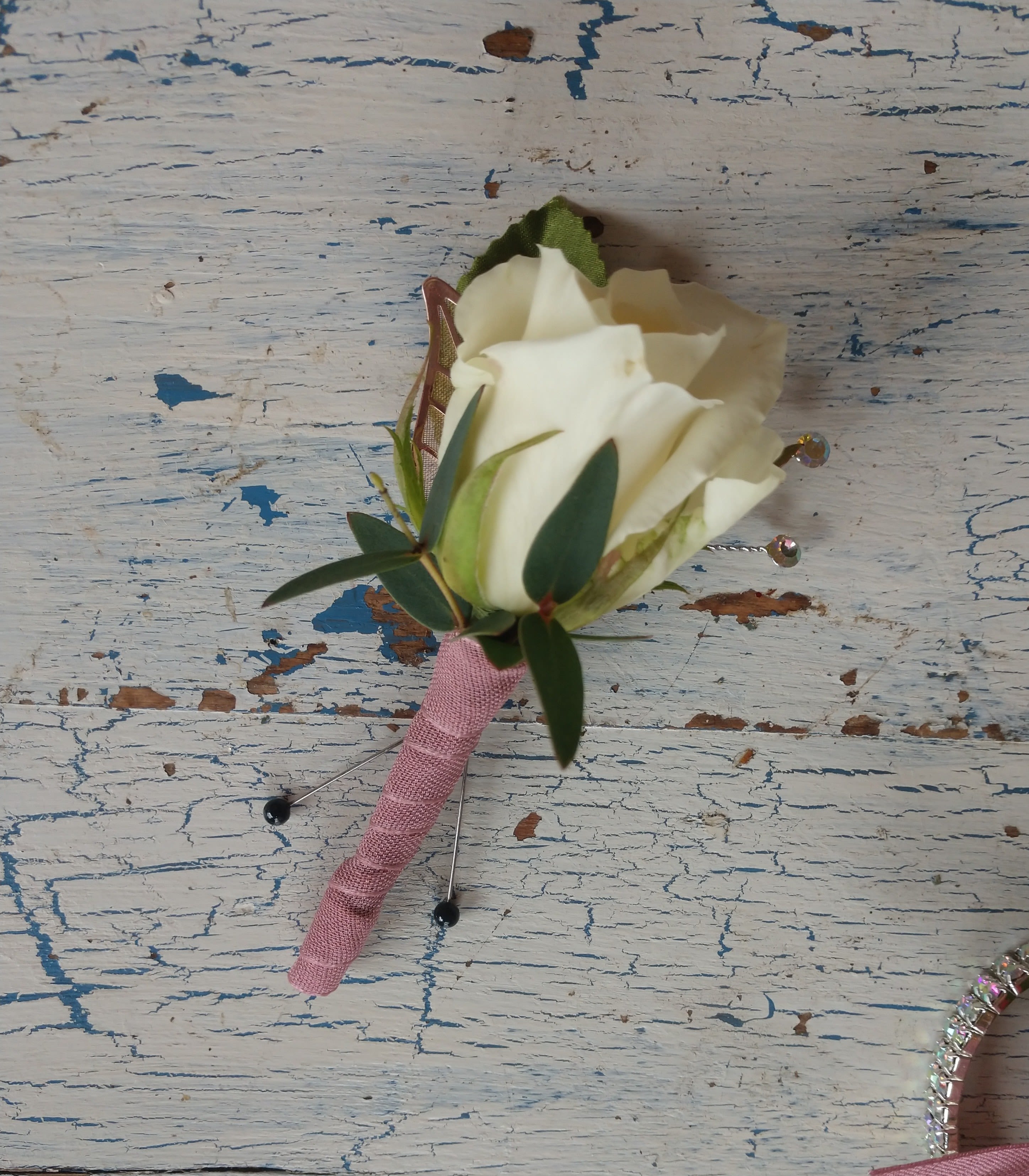 White Rose Boutonniere - A single white rose, clean as new-fallen snow, and dressed up with a sprinkle of baby's breath. A super choice for a classic tux. Accenting ribbon can be any complimenting color.