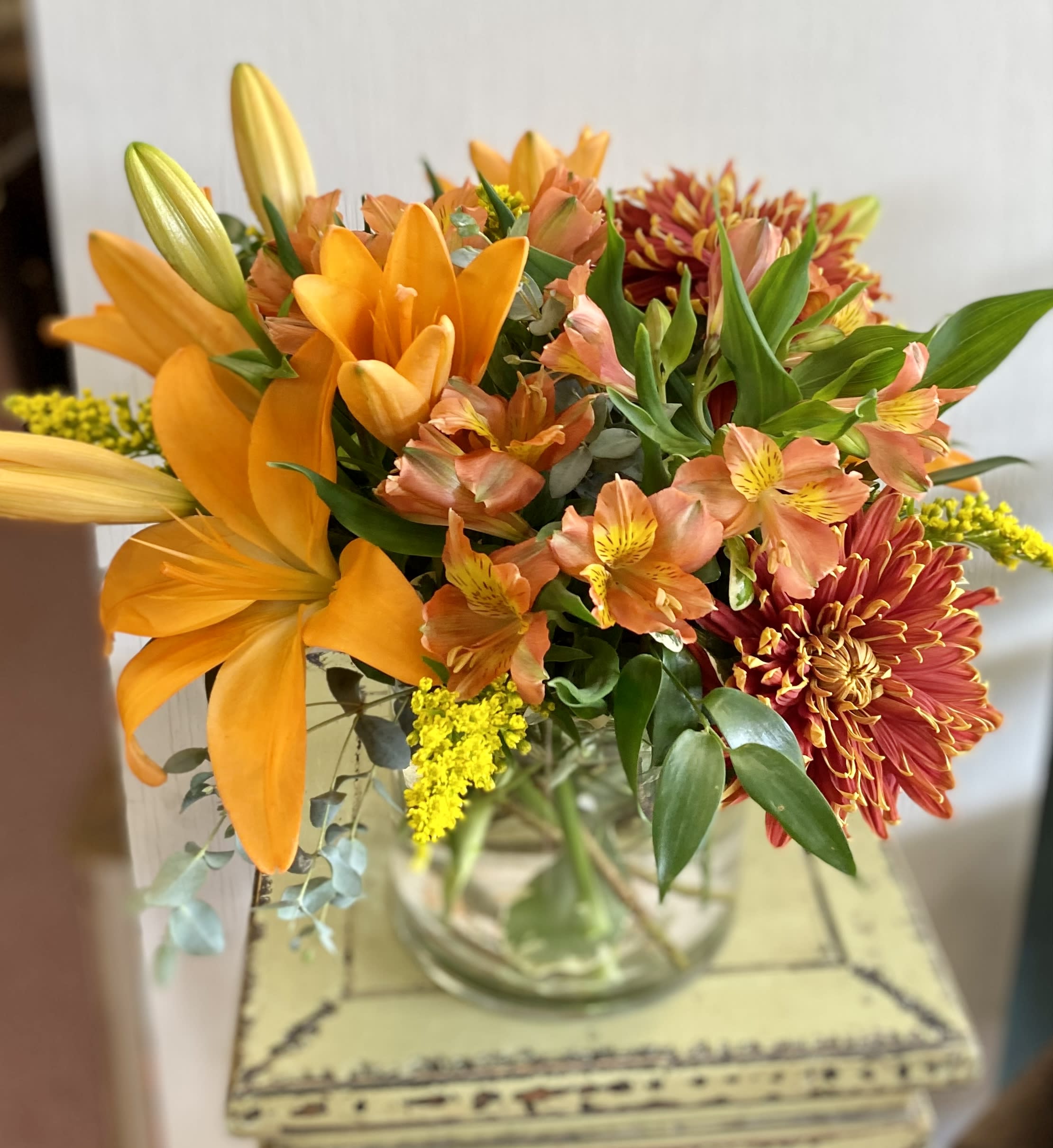Homespun Harvest Bouquet - A nod to the rich, vibrant colors of the autumn season, this inspiring bouquet adds a touch of glamour to the harvest months ahead. Chrysanthemums, alstromeria, and lilies are the stars. An excellent way to send a touch of fall beauty to your recipient to help them bring the magic of the season into their home. 
