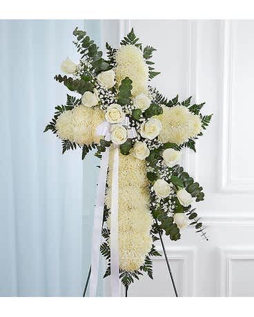 Sending Prayers White Standing Cross - Honor a lifetime of faithful devotion with our beautiful standing cross arrangement. Our expert florists handcraft each of these impressive displays with a bed of white mums in the shape of a cross, and accent with a cascade of crisp white roses. It is a beautiful way to offer peace and comfort during a difficult time. Standing cross arrangement of white football mums and roses; accented with babyâs breath and soft, lush greenery Appropriate for the funeral home Our florists use only the freshest flowers available, so colors and varieties may vary