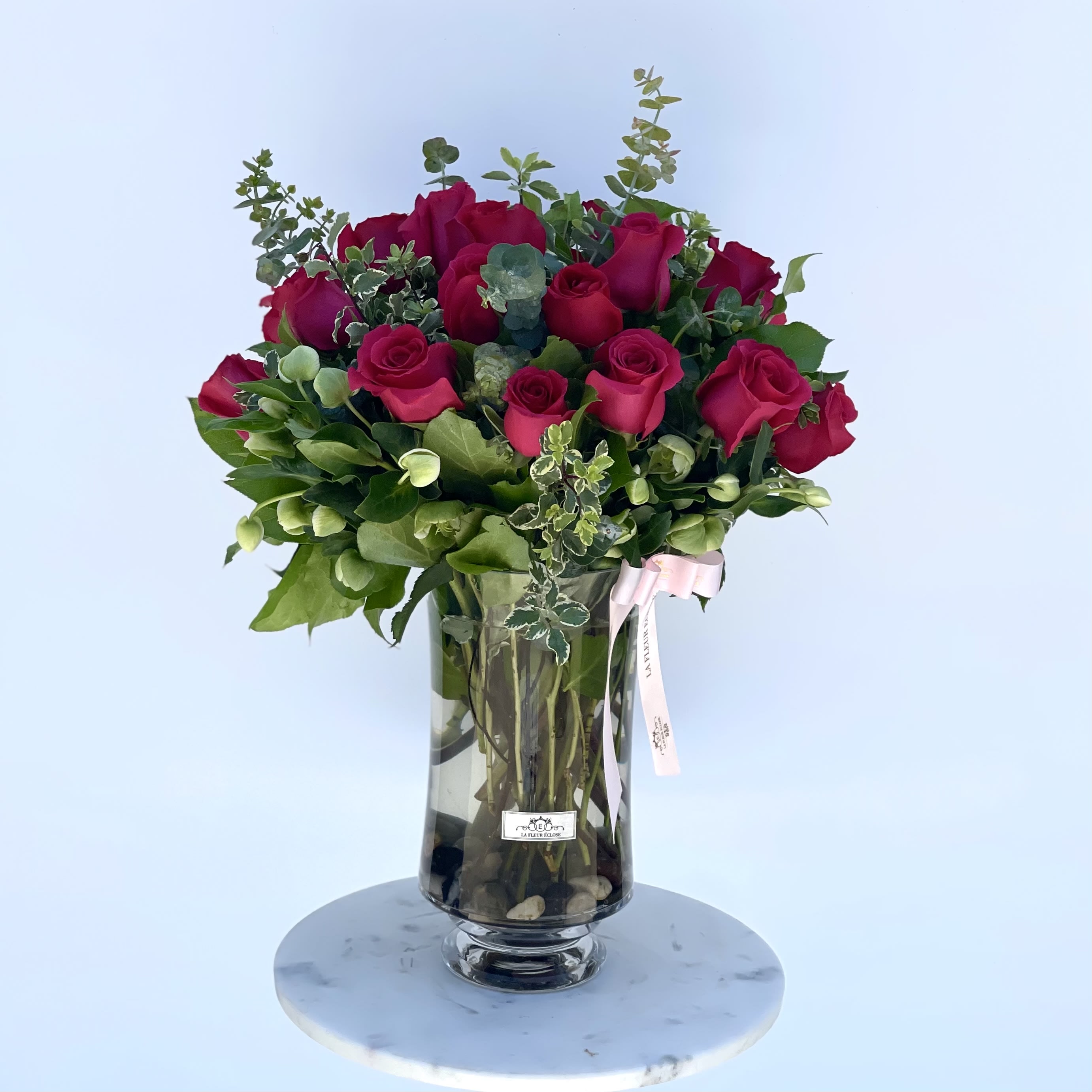A Budding Romance - This beautiful arrangement filled with our fresh roses and greenery can show your loved ones just how much they mean to you. The striking hot pink roses paired with our elegant vase work for just about any occasion! 