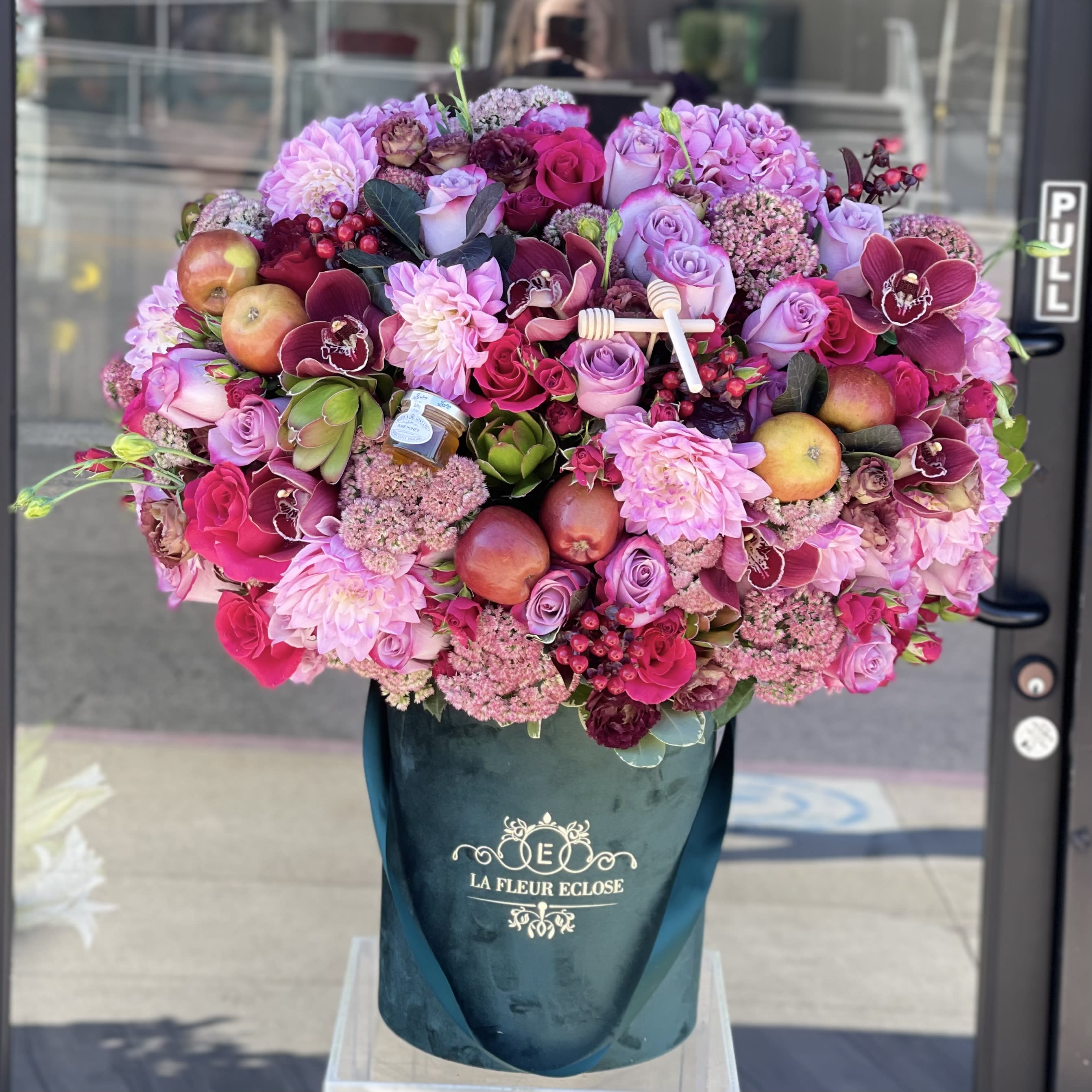 Rosh Hashanah - Beautiful arrangement of fresh flowers with honey and apples!  * for the deluxe size the box’s color will be changed to black 