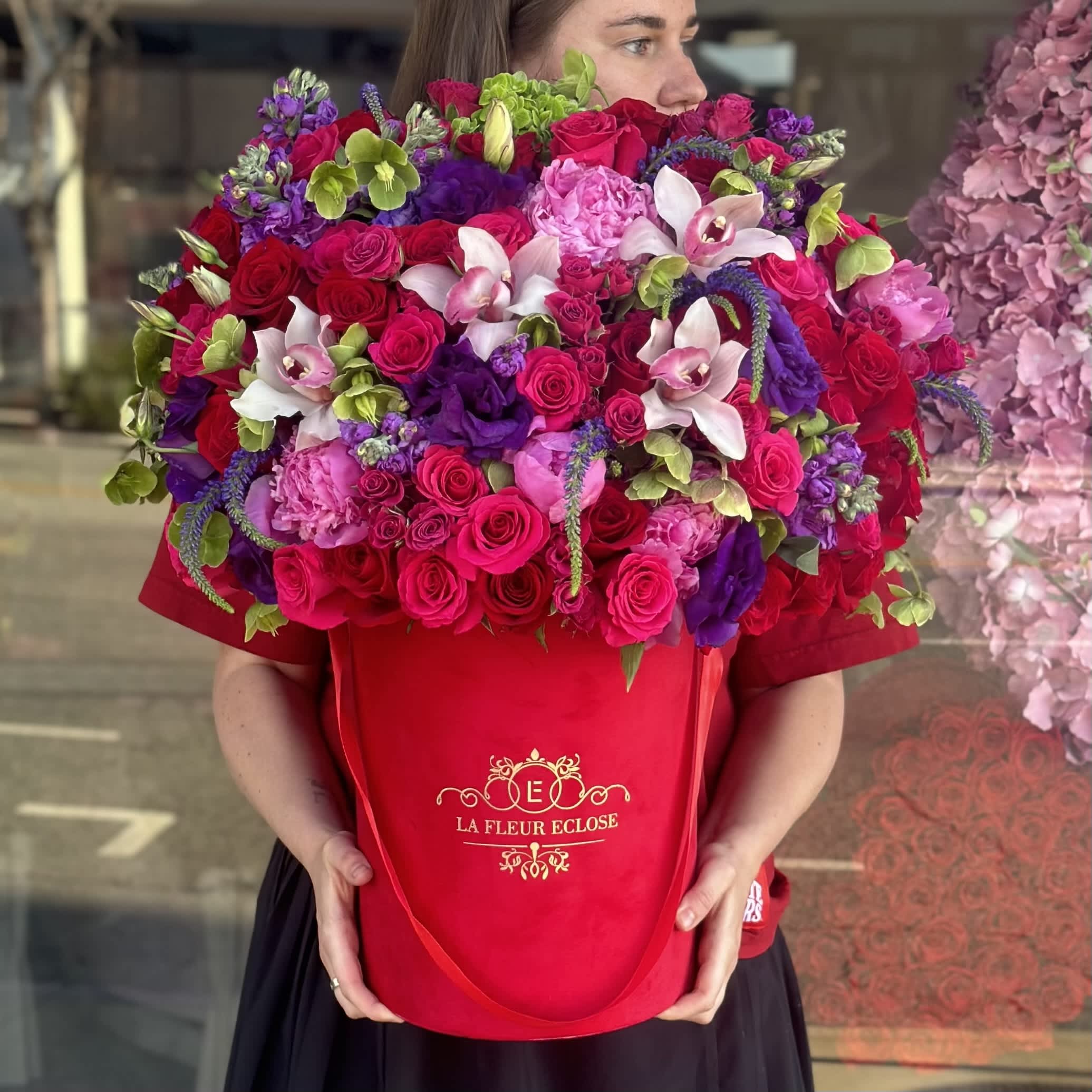 Red Garden - The flower arrangement features an elegant display of premium flowers beautifully arranged in a luxurious red velvet box. The rich red hues of the flowers complement the opulence of the velvet box, creating a striking and sophisticated look. The combination of premium red flowers and a red velvet box creates a stunning visual impact that is sure to impress and delight the recipie