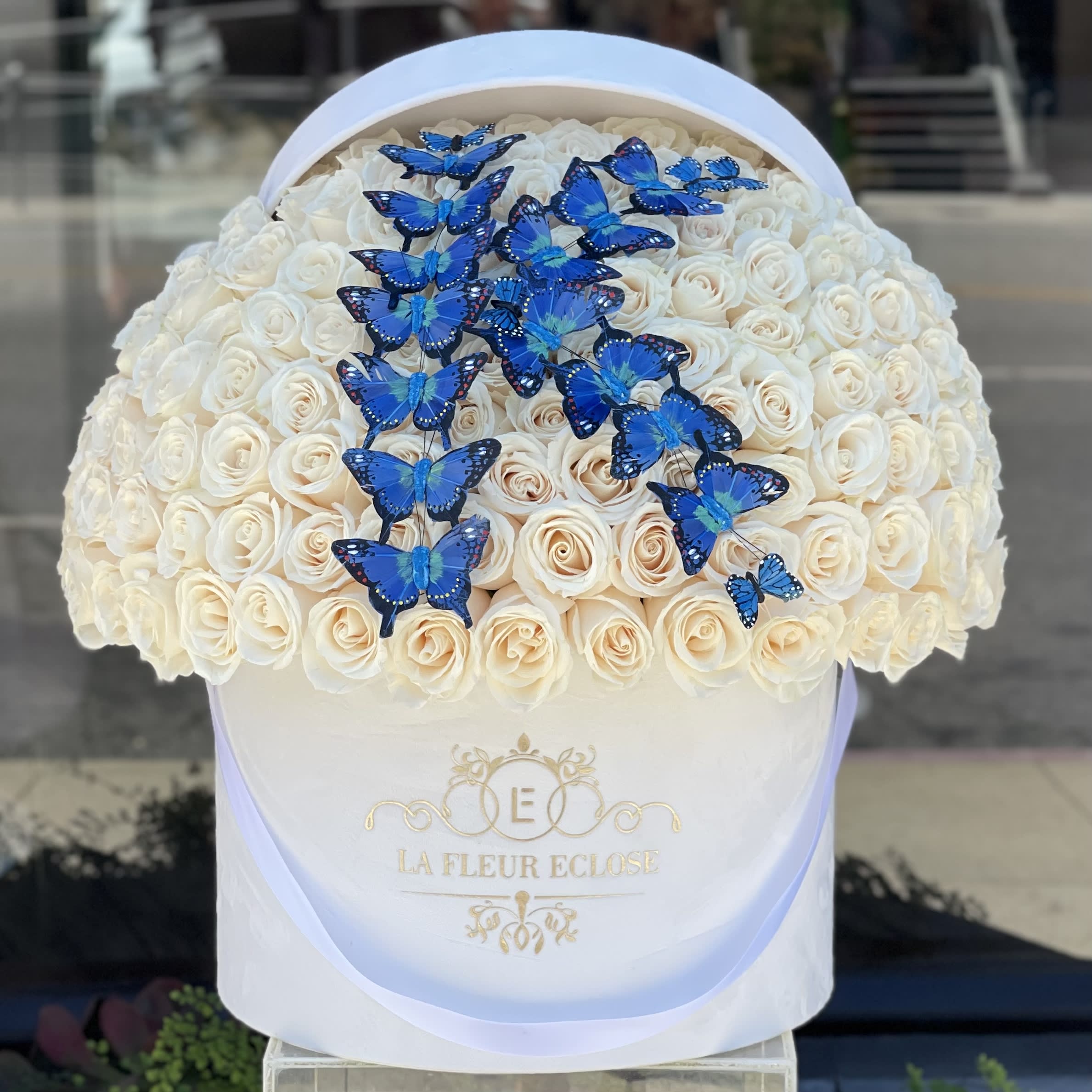 Welcome home - 100 roses with a butterflies letter in our signature velvet white box 