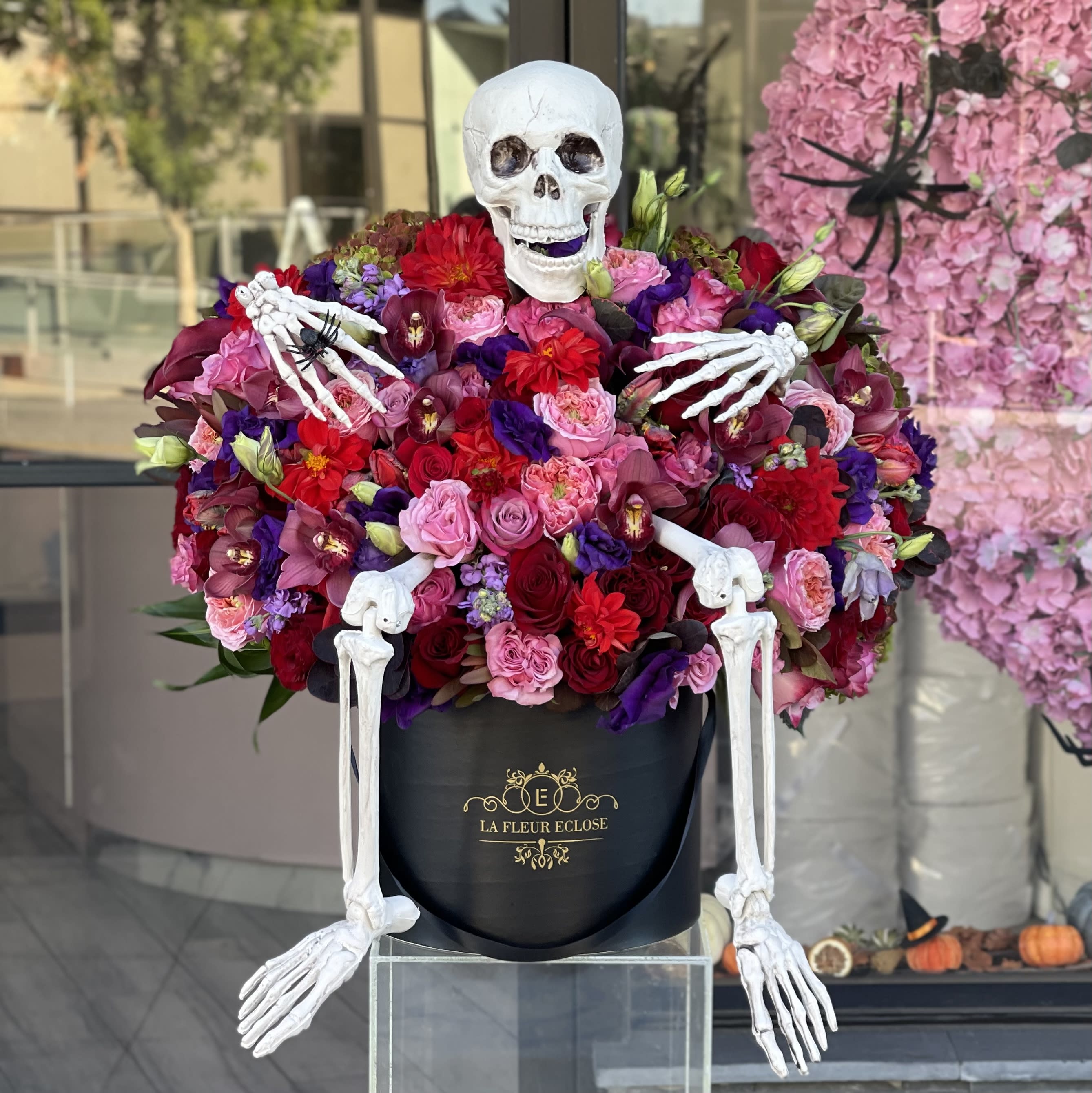 Skeleton in burgundy  - Large beautiful arrangement of burgundy and pink flowers with a sitting skeleton