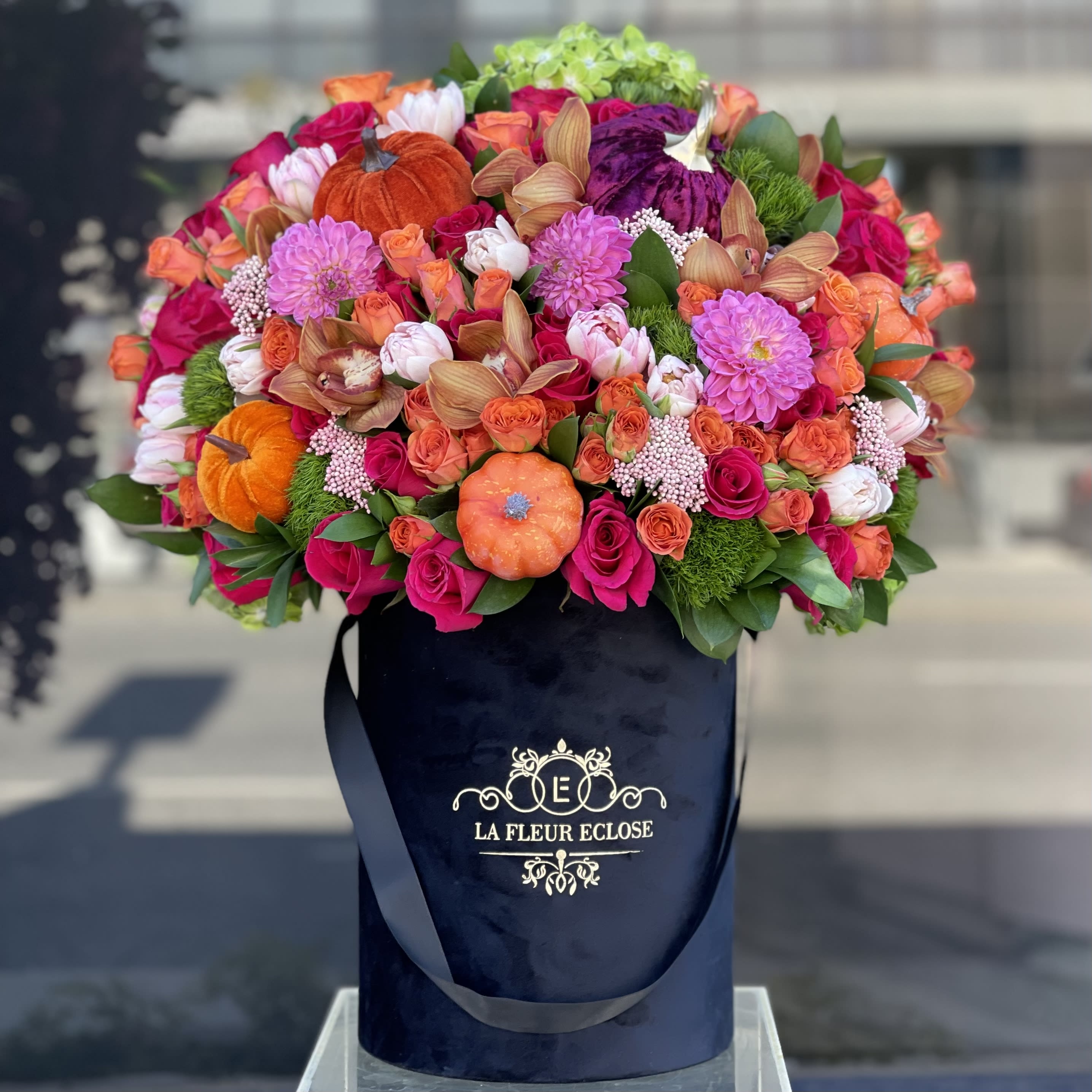 Happy pumpkins - Beautiful and bright arrangement of fresh flowers with colorful pumpkins on top in our signature black velvet box 