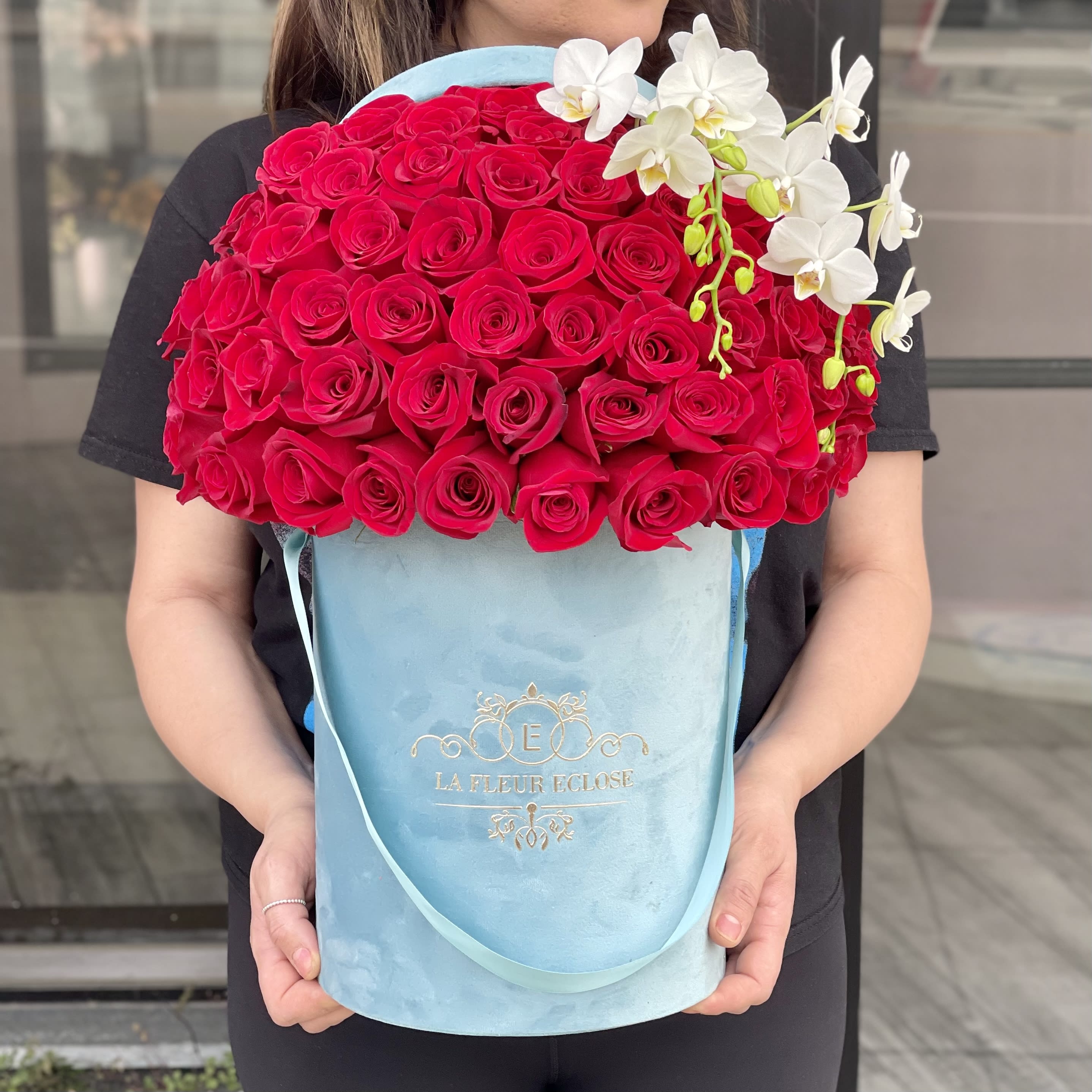 Miss Kelly - Standard 50 red roses in a turquoise signature box with a small orchid steam Deluxe 75 red roses 