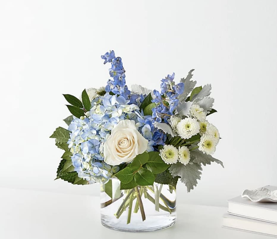Clear Skies Bouquet - Let this uplifting arrangement be reminders of the clear skies ahead. Capturing the feeling of hope that a new day brings, this bouquet is composed of voluminous hydrangea blooms and vibrant belladonna delphinium to refresh their mood.