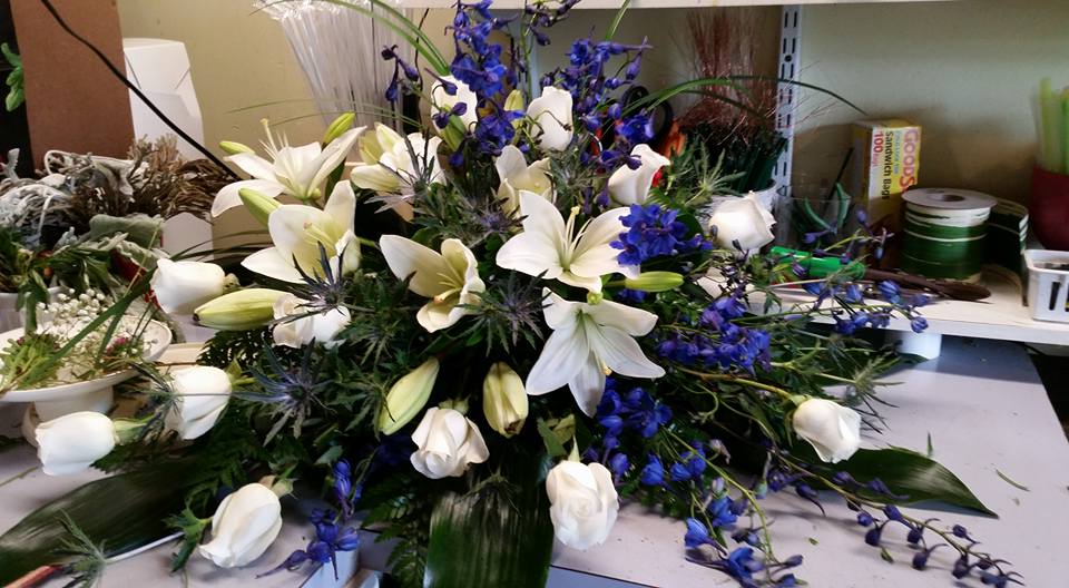 Blue and White Blooming Casket Blue and White Blooming Casket - This beautiful casket spray filled with the freshest selection of blue and white blooms is the perfect symbol of sympathy. The beauty and elegance of this sympathy casket spray … is a blend of lilies, roses, blue delphinium, blue thistle, and a mix of seasonal greens. Color changes can be made by request.