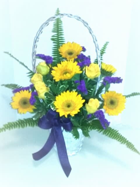 Sunny Memories Sunny Memories - Send a memorable gift of bright sunflowers,yellow roses and purple statice in a white wicker basket with assorted greenery,