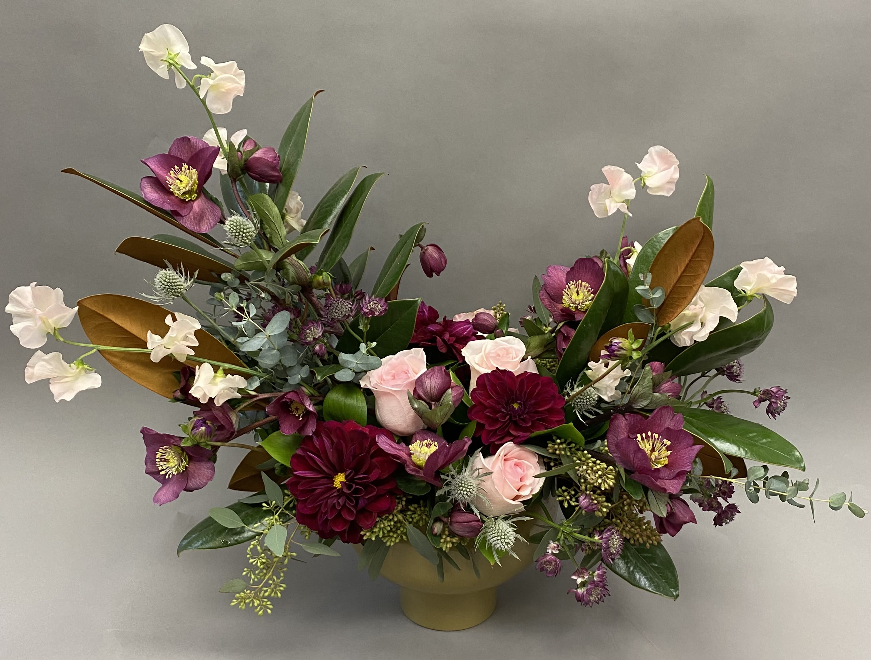 Floral Majesty  - A beautiful arrangement with purple blush tone flowers in a gold modern container. 