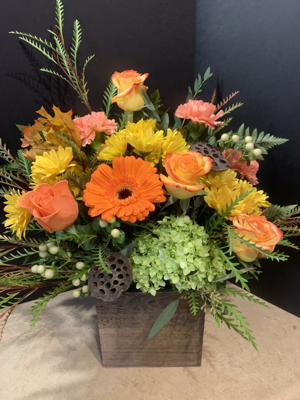 Festive Fall  - Fall flowers in a rustic wooden planter. Features orange roses, fall mums and Gerbera daisies. Colors may vary slightly, but overall style and feeling will be the same.  