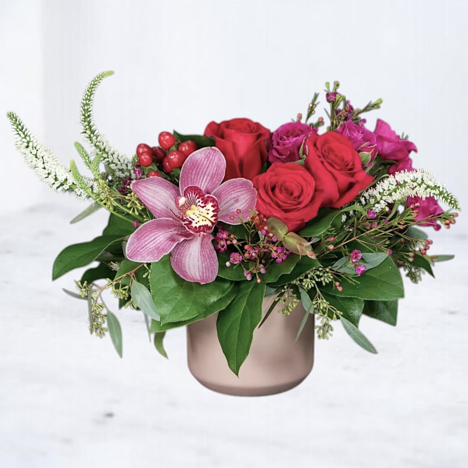 Electric Pink &amp; Peach Celebration Flowers - Vibrant, fresh, and playful, this bouquet features bold pink and coral blooms layered with textural greens. A fun and expressive gift for birthdays, cheer-ups, or new beginnings. Designed in a matte rose-gold vase, this arrangement offers a powerful, contemporary expression of beauty and emotion.  Ideal for romantic occasions, modern anniversaries, luxury gifting, or making a dramatic floral statement.