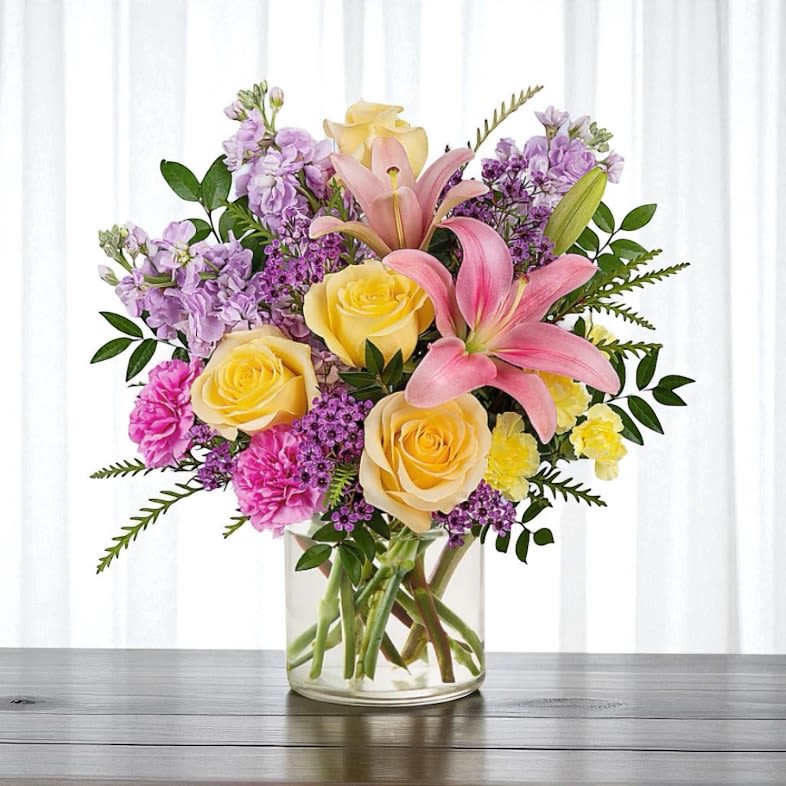 A Walk in Spring A Walk in Spring - Colorful, beautiful spring blooms including pink lily, carnation and bold yellow roses arranged to bring cheer, smiles and beauty to your loved one.