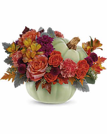 Telefora's Sage Harvest Pumpkin - Bring autumn's charm to your table with Teleflora's Sage Harvest Bouquet, a delightful centerpiece adorned with rustic elegance. Nestled in a timeless hand-painted ceramic pumpkin, its exquisite details and warm, earthy hues create a captivating focal point. This arrangement features orange roses, spray orange roses, orange alstroemeria, orange carnations, purple button spray chrysanthemums, purple cushion spray chrysanthemums, dusty miller, seeded eucalyptus, and is delivered in Teleflora's Sage Harvest Pumpkin. The perfect blend of autumn hues and floral elegance for any occasion. Orientation: All-Around  SUBSTITUTION POLICY – We always deliver the freshest flowers! Please note the bouquet pictured reflects our original design.  If the exact flowers or container in this arrangement are not available, we will create a beautiful bouquet with the freshest available flowers.
