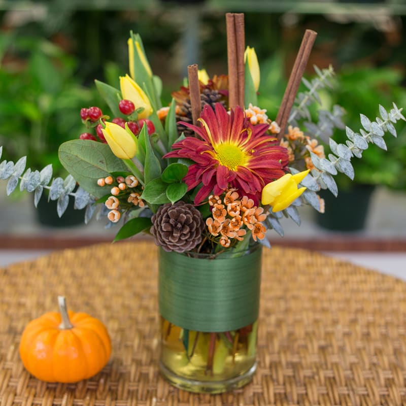 Autumn elegance - Beautiful fall fresh flowers arranged in a leaf wrapped glass vase