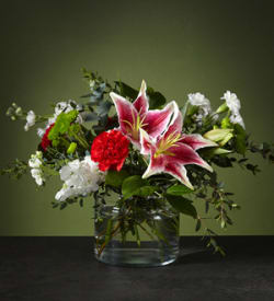 Candy Cane Lane  - The starfighter lily's white exterior will bloom with bright color on the inside, complementing the classic ruby carnations.  Please Note: The bouquet pictured reflects our original design for this product. While we always try to follow the color palette, we may replace stems to deliver the freshest bouquet possible, and we may sometimes need to use a different vase.