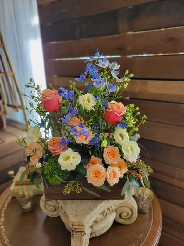 Field of Flowers - Garden like arrangement of mixed flowers &quot;growing&quot; out of a wooden box. Lisaianthus, Delphiniums and standard Roses and spray roses in pleasing spring colors.