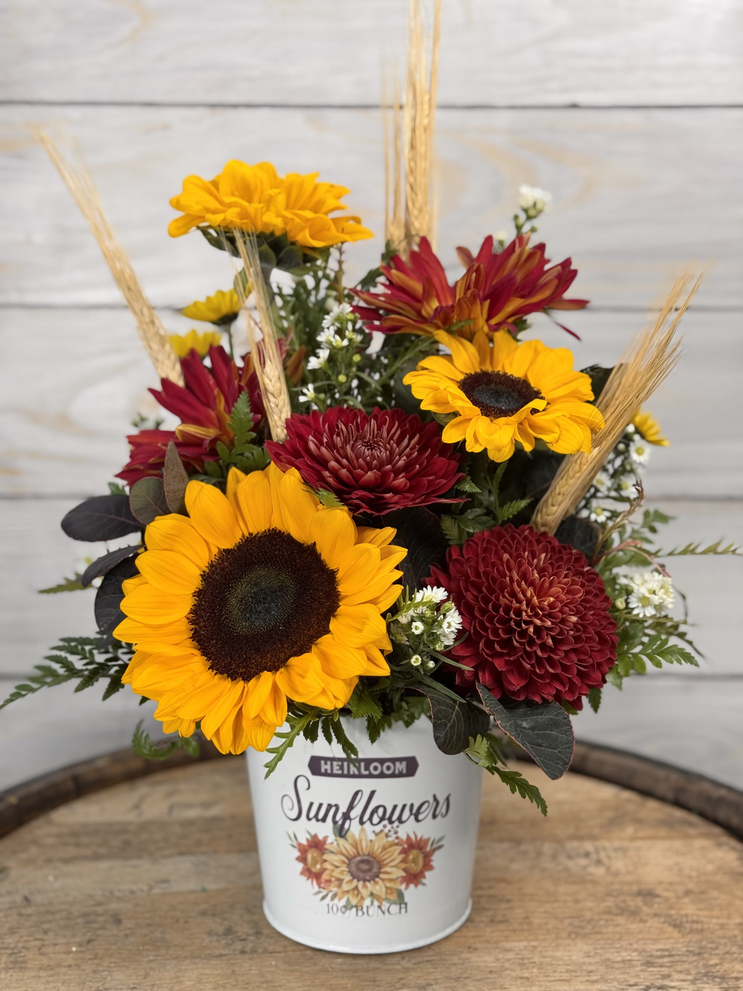 Bucket of Sunshine Bucket of Sunshine - A tin bucket with everyone's favorite, Sunflowers! Along with rovers and cremons. You can't get more fall than this arrangement!