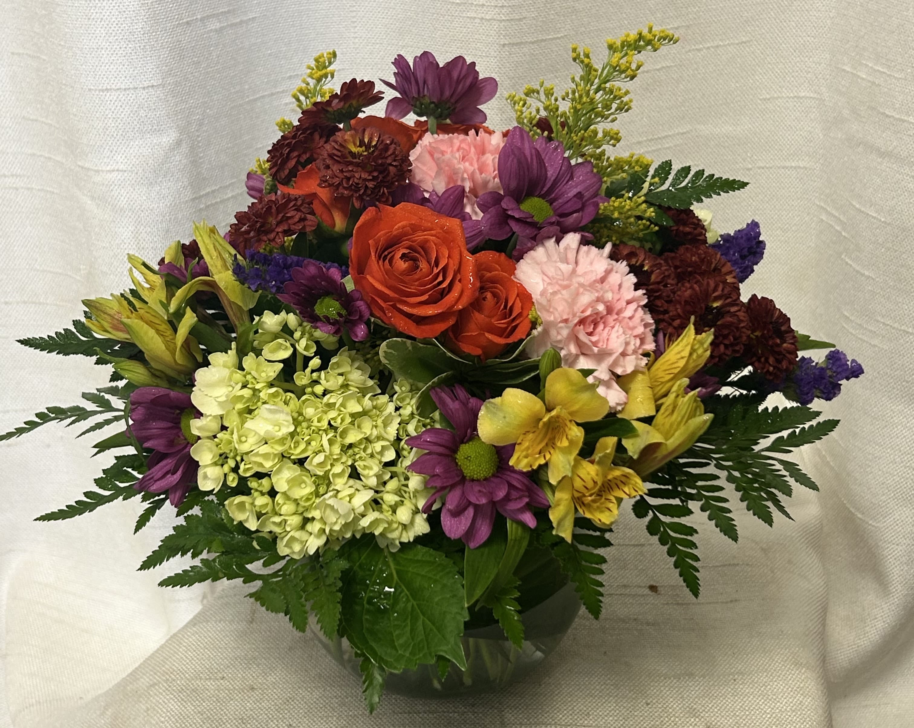 Pumpkin Patch - Introducing the &quot;Pumpkin Patch&quot; Thanksgiving Flower Arrangement, a stunning blend of green mini hydrangea, purple daisies, orange spray roses, orange alstroemeria, solidago as filler, and fresh greenery.  
