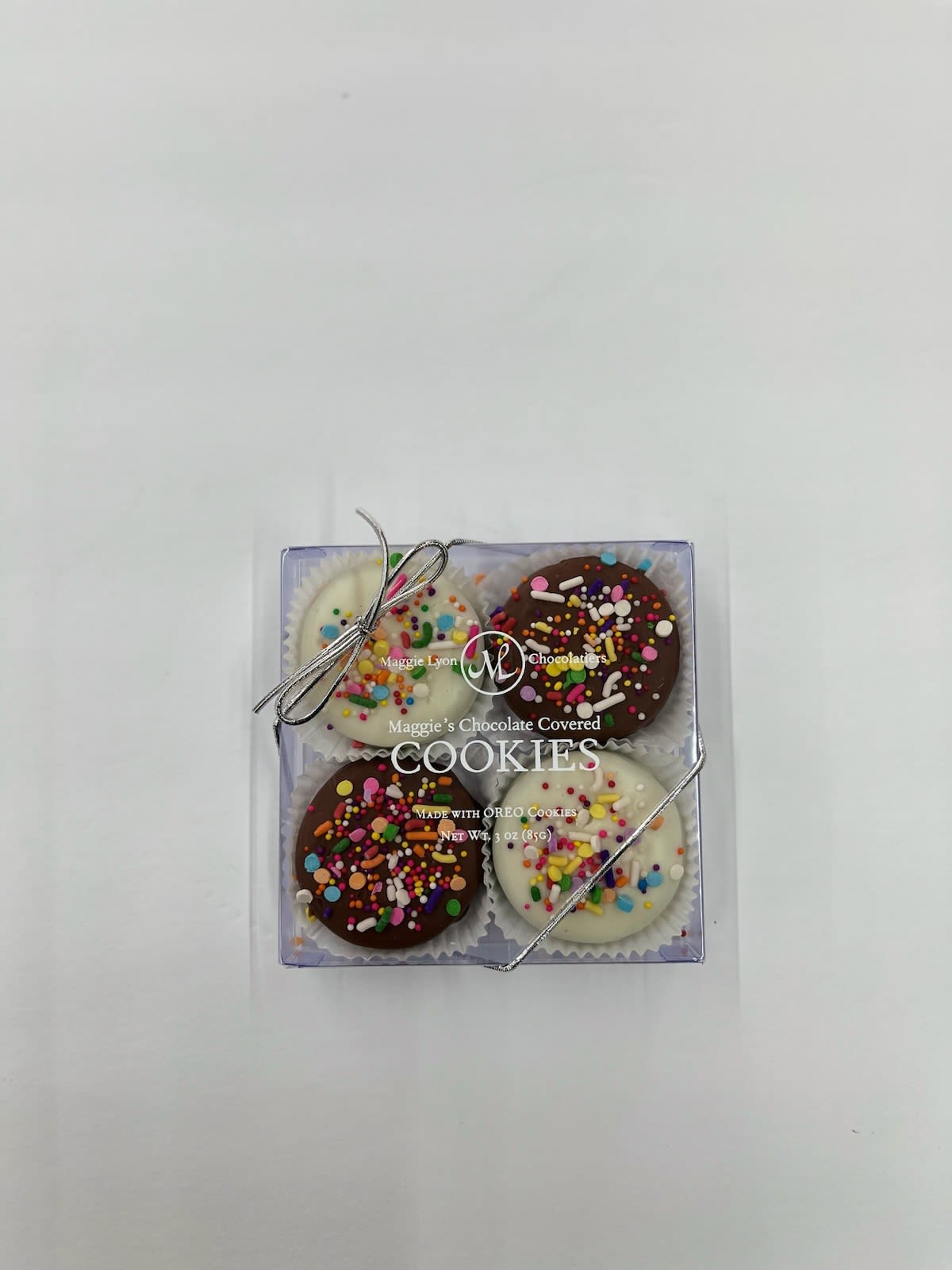 4 pc Chocolate Covered Oreos with Pastel Drizzle - Maggie Lyons 4 pc Chocolate Covered Oreos with Pastel Drizzle - Maggie Lyons - Maggie Lyon’s milk and white chocolate-covered cookies, with rainbow explosion decorations. Made with Oreo cookies.
