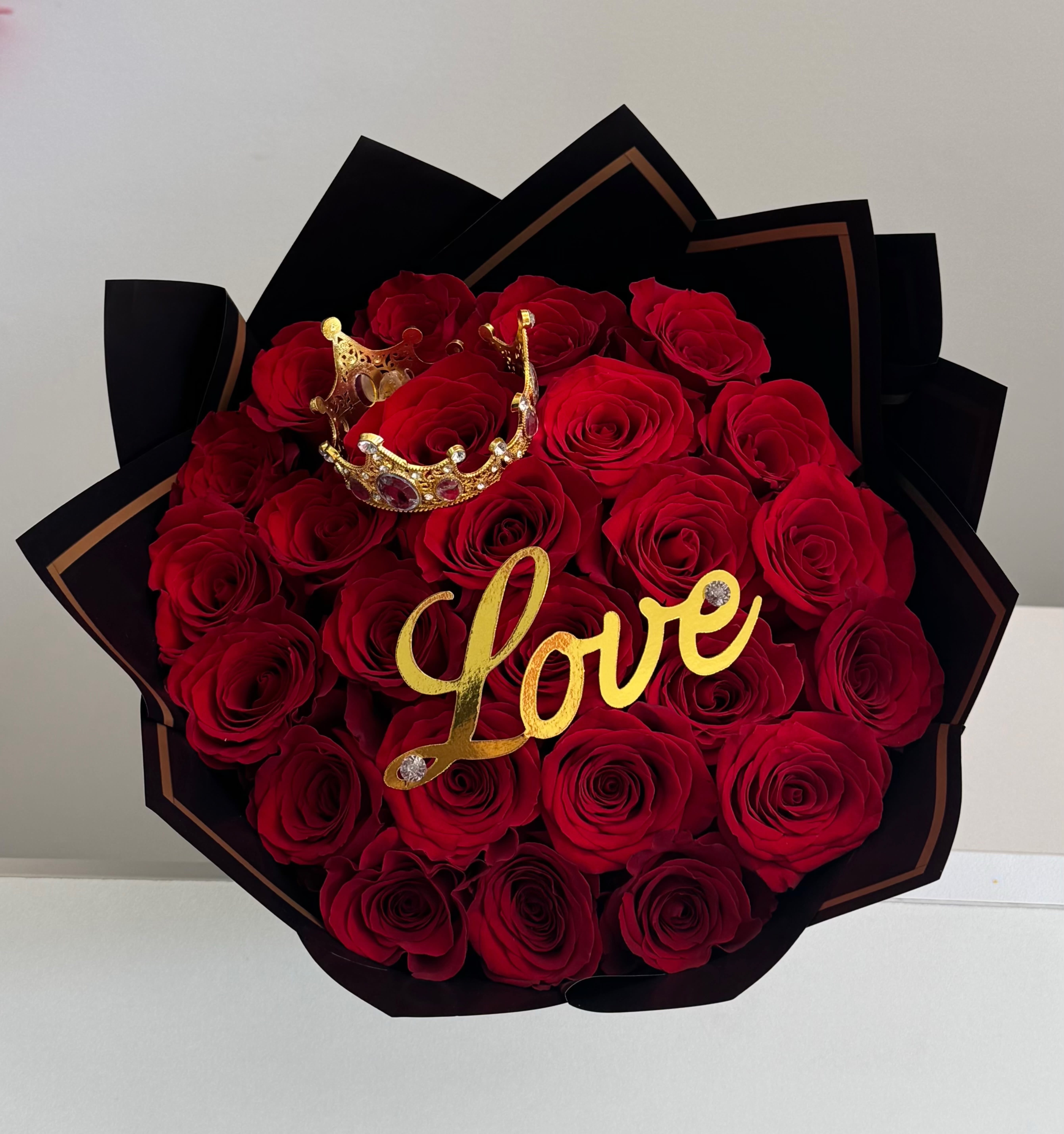 Red Roses Bouquet. for love - ️Red Roses Bouquet with Crown and “Love” – Romantic Edition  A gift that captivates at first sight. This red roses bouquet is wrapped in elegant black luxury paper with golden borders, featuring a decorative golden crown and an acrylic “Love” sign. Designed for unforgettable romantic gestures, it is available in three sizes and delivered the same day across Miami and nearby areas. Send roses of love, forgiveness, passion, romance, reconciliation, devotion, desire, hope, commitment, and eternal affection to win back her heart  Available Sizes:   25 roses – romantic and delicate  50 roses – impactful bouquet (as shown in the image)  75 roses – an unforgettable declaration of love  Includes:   Long-stemmed natural red roses (25, 50, or 75)  Decorative golden crown with pearls and shining stones  Golden acrylic “Love” topper sign  Luxury black wrapping paper with gold accents  Impeccable presentation, ready to gift  Same-day delivery guaranteed in less than 4 hours in Miami and surrounding areas  Perfect For: ️ Anniversary or Valentine’s Day gifts  Romantic declarations of love  Elegant and sophisticated surprises 