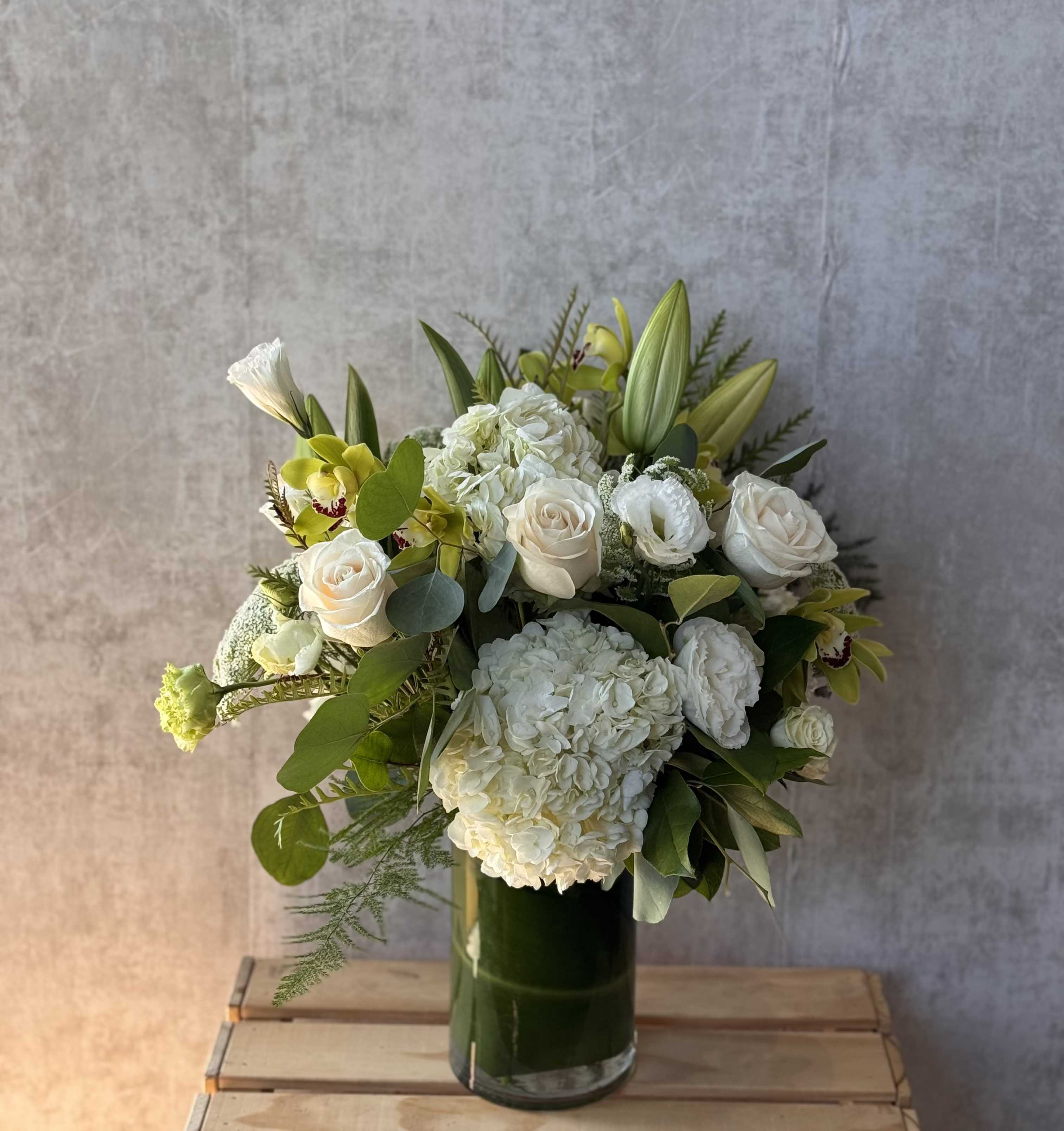 Pure Love Pure Love - The Pure Love arrangement exudes a sense of purity and calm, featuring large white blooms gently accented with touches of fresh green foliage.