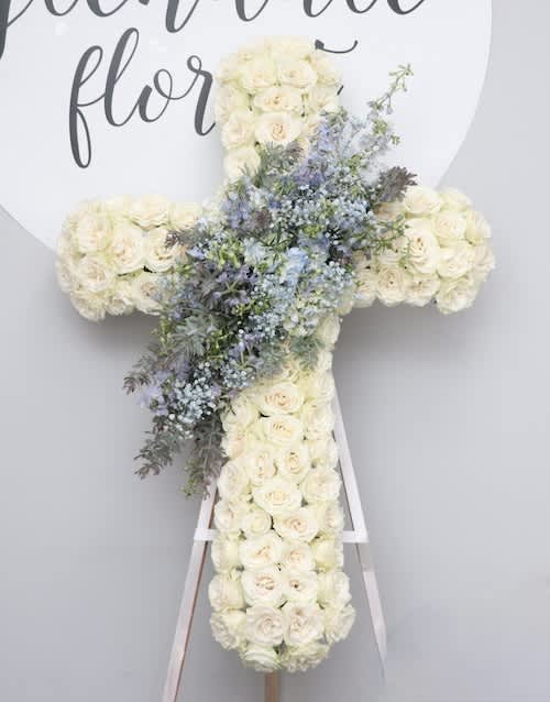 Blue Skies Cross Blue Skies Cross - This sympathy cross is made with white roses and accented with a light blue design in the middle. A perfect choice if you are looking to add subtle color to a service. We include easel, printed banner and delivery (some fees may apply). An additional banner can be added for $15. Standard size is 30'', deluxe is 36'', and premium is 42''.