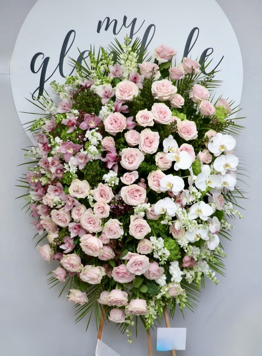 Pink Orchid Spray Pink Orchid Spray - This beautiful funeral spray is made with pink roses and includes a side of cymbidium orchids and white phalaenopsis orchids. This grand design is a lovely choice to honor your loved one. We include easel, printed banner and delivery (some fees may apply). An additional banner can be added for $15. Standard size is 30'' wide, deluxe is 36'', and premium is 42''.