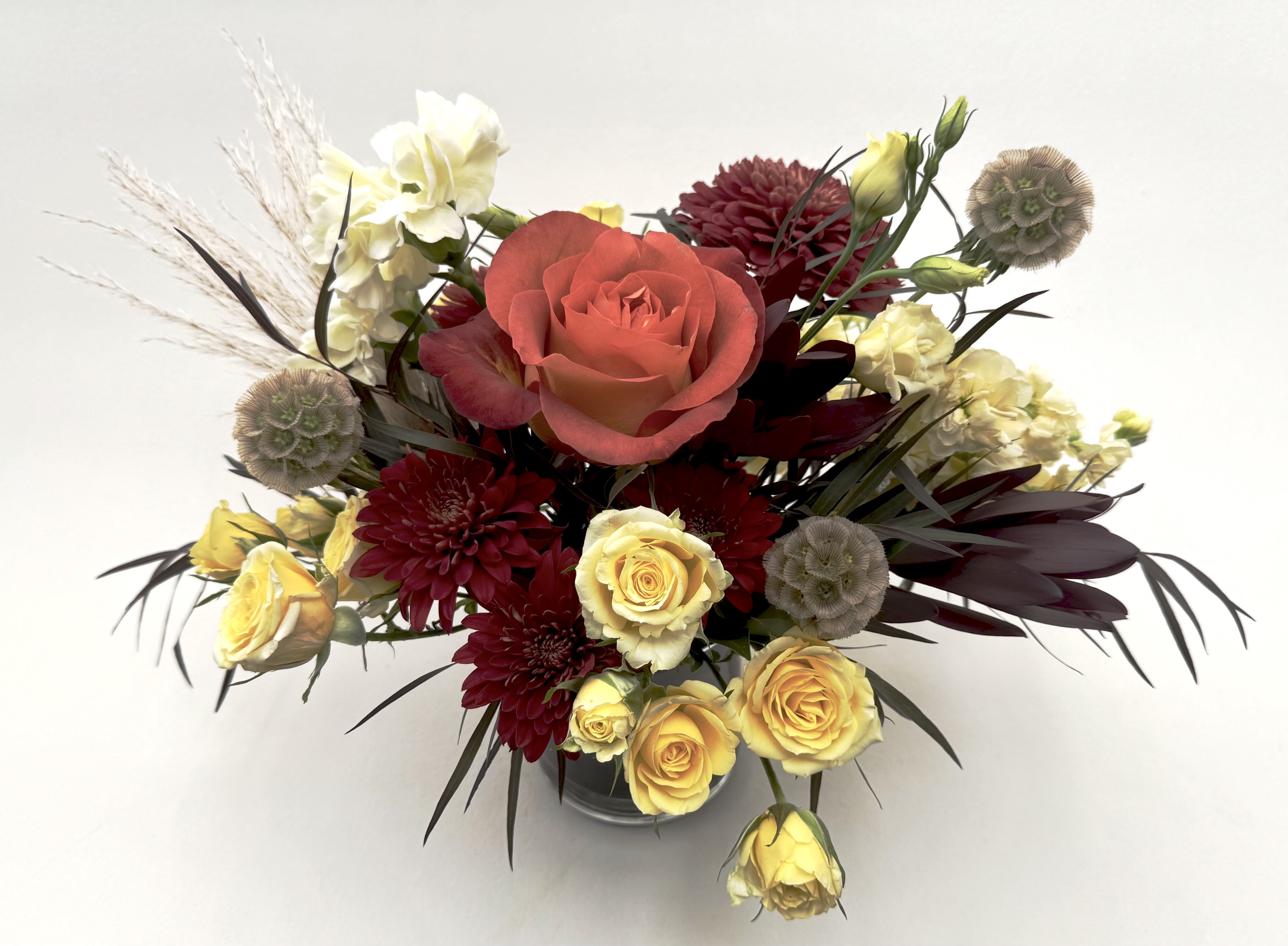 Fall Splendor   - Celebrate autumn with our Fall Splendor arrangement! Our Fall Splendor is a lush arrangement with autumnal burgundy, orange and cream flowers arranged in a glass cylinder vase with a ti leaf wrap.    Delivery Info- We make all of our deliveries after 1pm every day. If the weather is very cold, we prefer not to leave the flowers outside. Please let the recipient know that they should expect delivery.